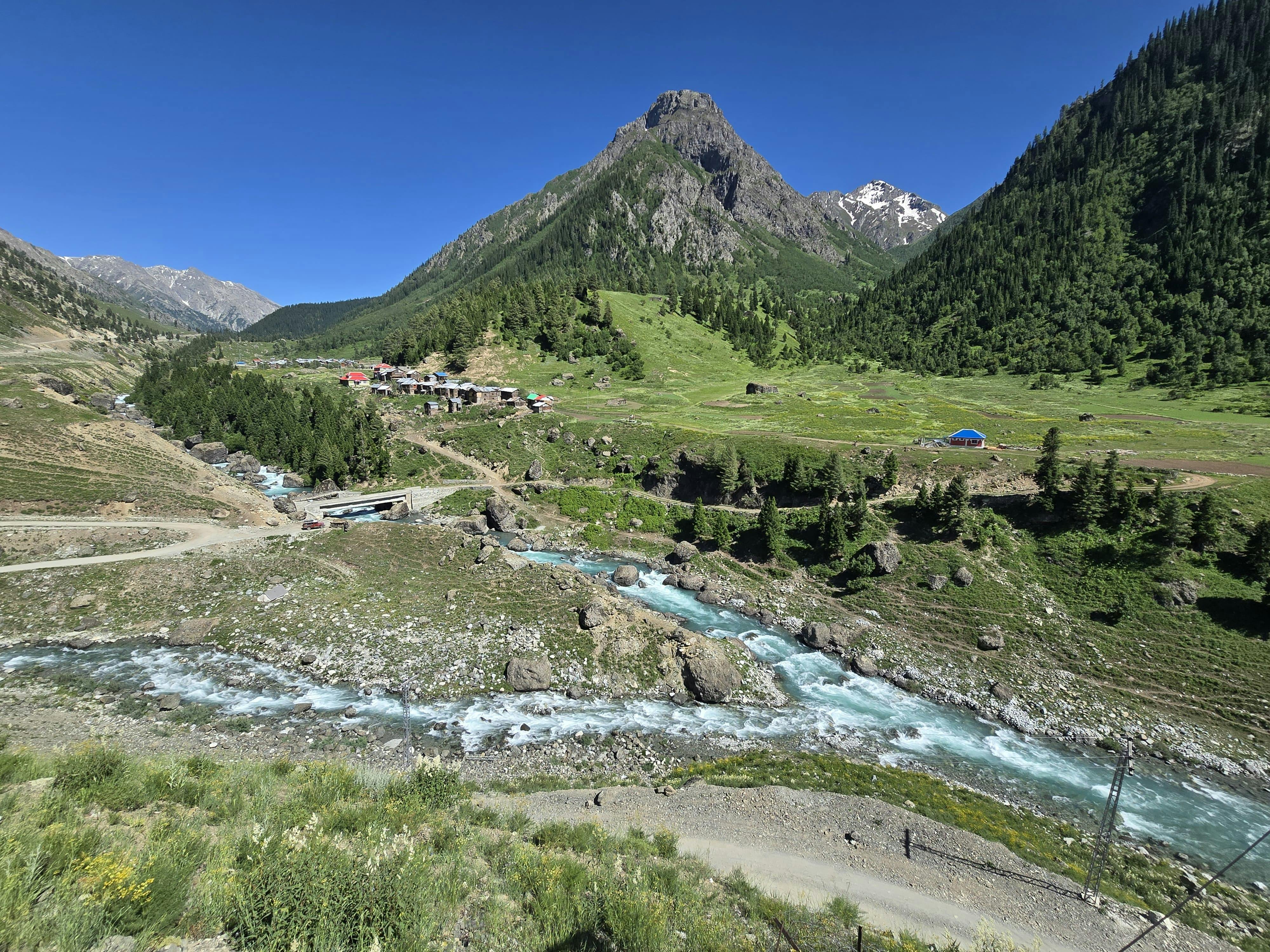 Gratis Una pittoresca valle di montagna con un fiume che scorre e un cielo azzurro e limpido, ideale per gli amanti della natura. Foto a disposizione