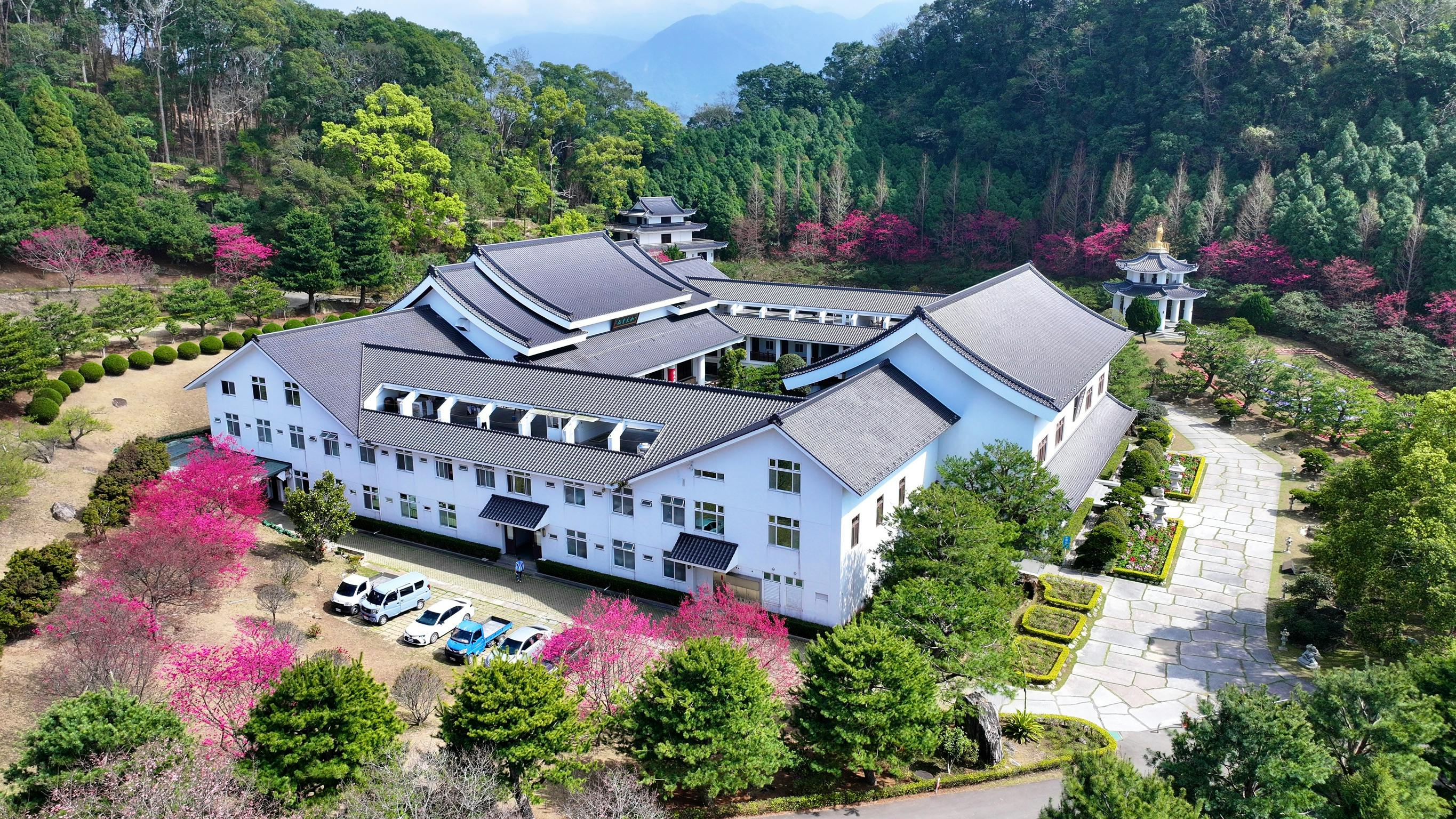 Gratis Vista aerea di un edificio tradizionale asiatico circondato da una vegetazione lussureggiante e fiori. Foto a disposizione