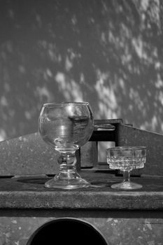 Black and white photo of vintage glassware casting intriguing shadows.