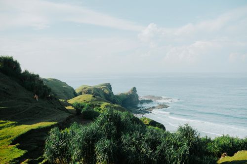 Free Scenic view of lush green cliffs overlooking the ocean on a sunny day. Stock Photo