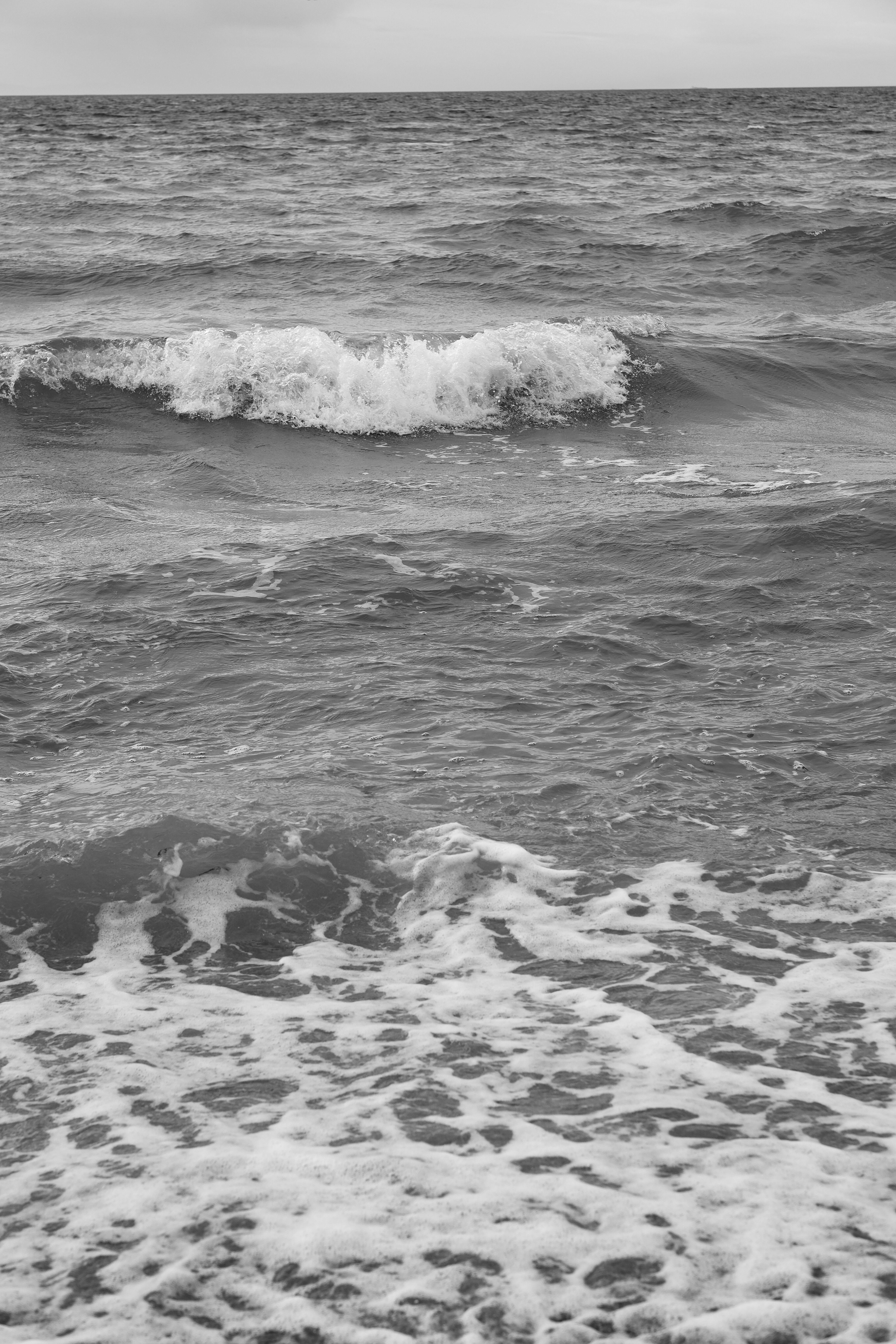 ฟรี ภาพขาวดำของคลื่นทะเลที่ซัดสาด ให้ความรู้สึกสงบและไร้กาลเวลา คลังภาพถ่าย