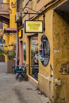 A vibrant vintage store facade on a bustling street, showcasing urban charm.