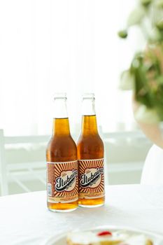 Two Tubaina soda bottles on a bright, elegant table setting in São Paulo.