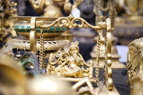 Free Detailed brass sculpture of Baby Krishna on a swing, showcasing traditional Indian craftsmanship. Stock Photo