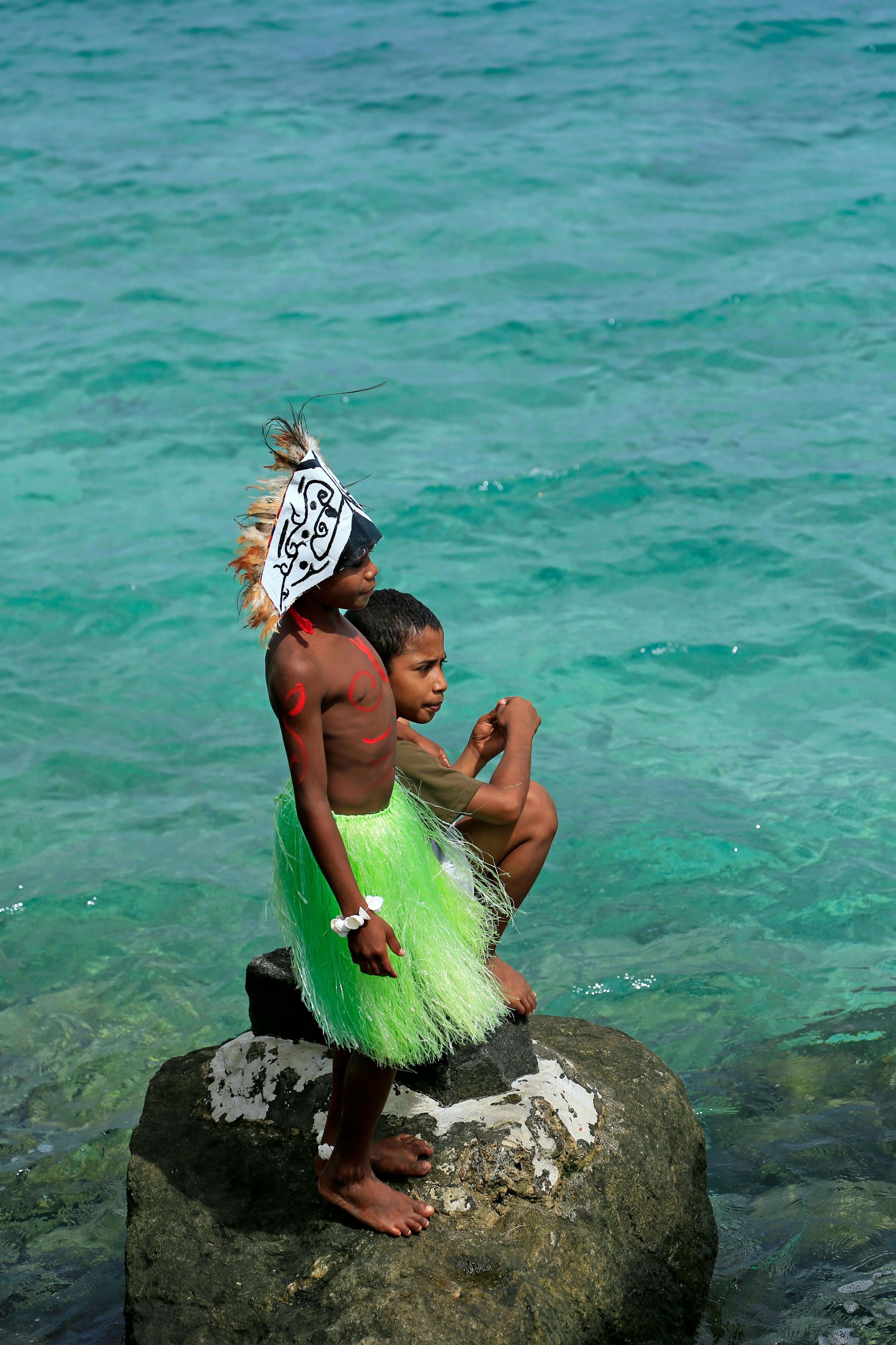 Children in Traditional Attire by the Sea