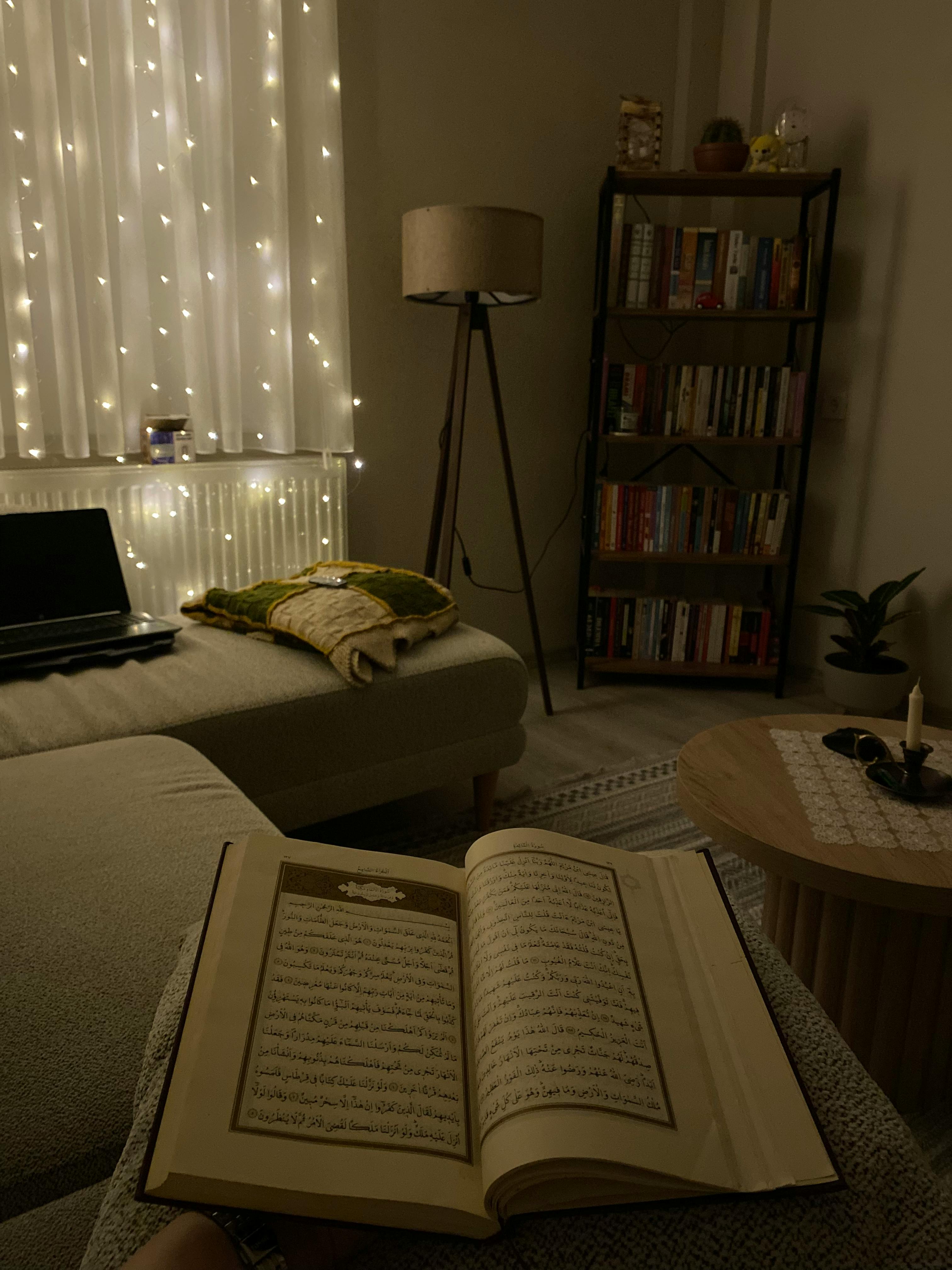 bezplatná Okouzlující vnitřní scéna s otevřenou knihou, měkkým osvětlením a útulnou atmosférou ideální pro relaxaci. Základová fotografie