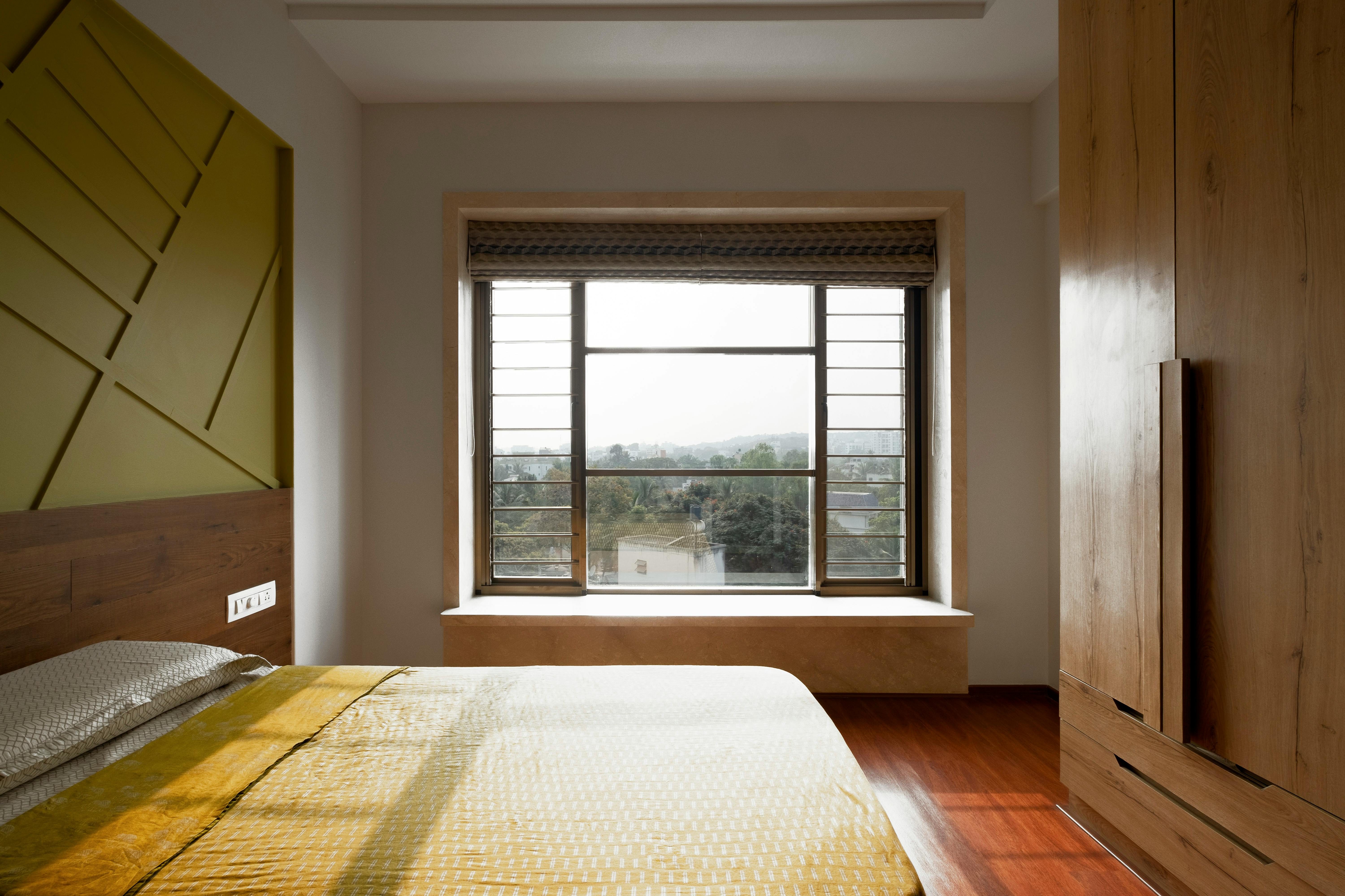 Gratis Un'accogliente camera da letto a Pune con arredi in legno, illuminata dalla tenue luce del sole pomeridiano che filtra attraverso un'ampia finestra. Foto a disposizione