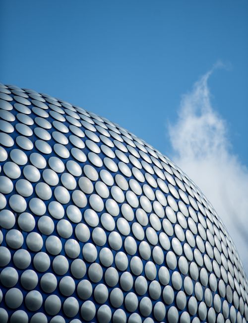 Free Iconic rounded metallic facade of Selfridges, Birmingham under a clear blue sky. Stock Photo
