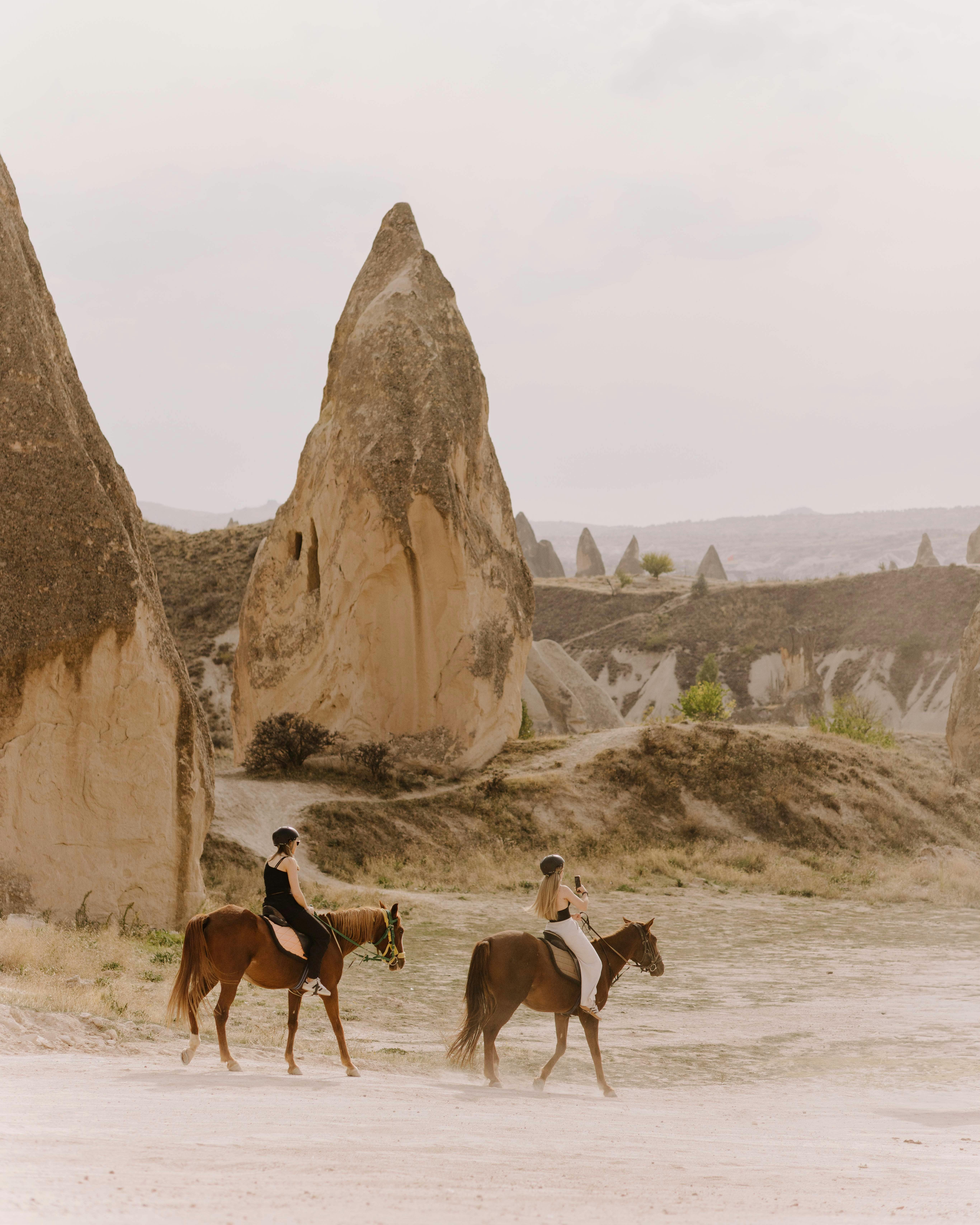bezplatná Prozkoumejte úchvatné skalní útvary Kappadokie na koni pod pastelovou oblohou. Základová fotografie
