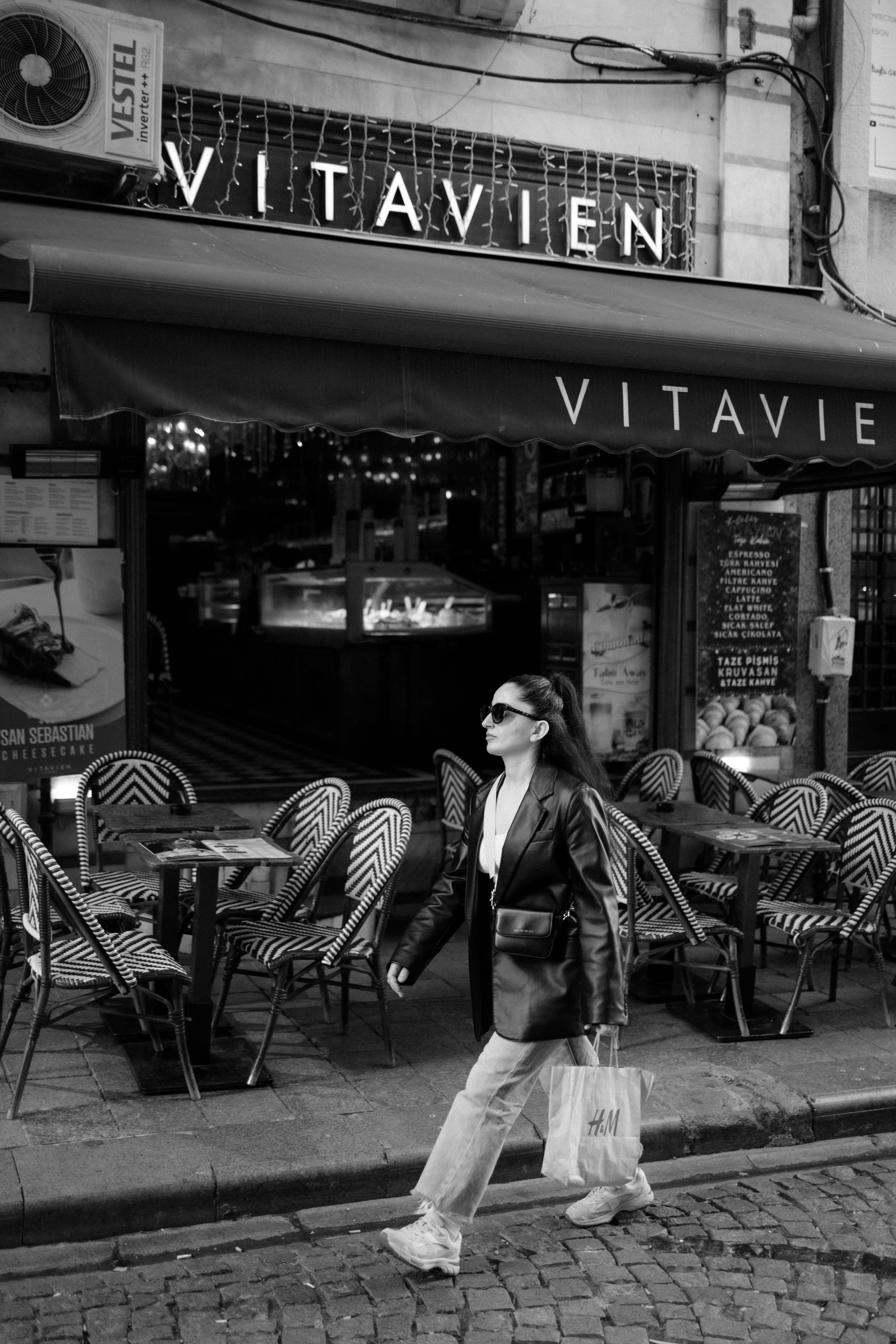 Miễn phí Ảnh đen trắng chụp một người phụ nữ đi ngang qua một quán cà phê ở Thổ Nhĩ Kỳ, toát lên vẻ thanh lịch của người thành thị. Ảnh lưu trữ