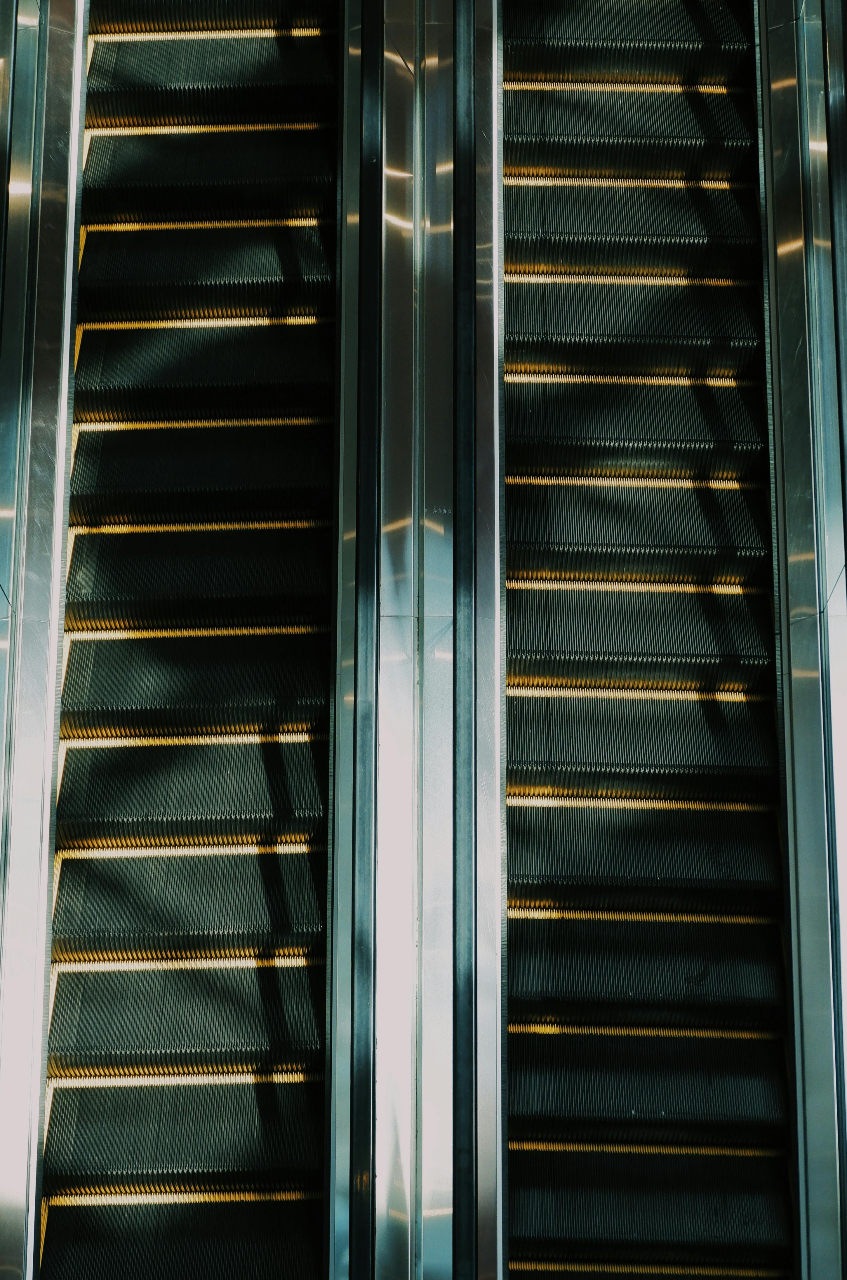 Miễn phí Thang cuốn đối xứng với bậc thang bằng kim loại và vạch kẻ màu vàng trong không gian trong nhà. Ảnh lưu trữ