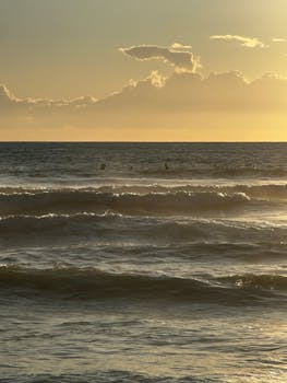 Serene view of a golden sunset over the Mediterranean Sea with gentle waves.
