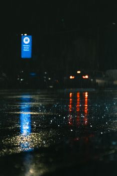 Moody street view capturing rainy reflections in Melbourne at night.