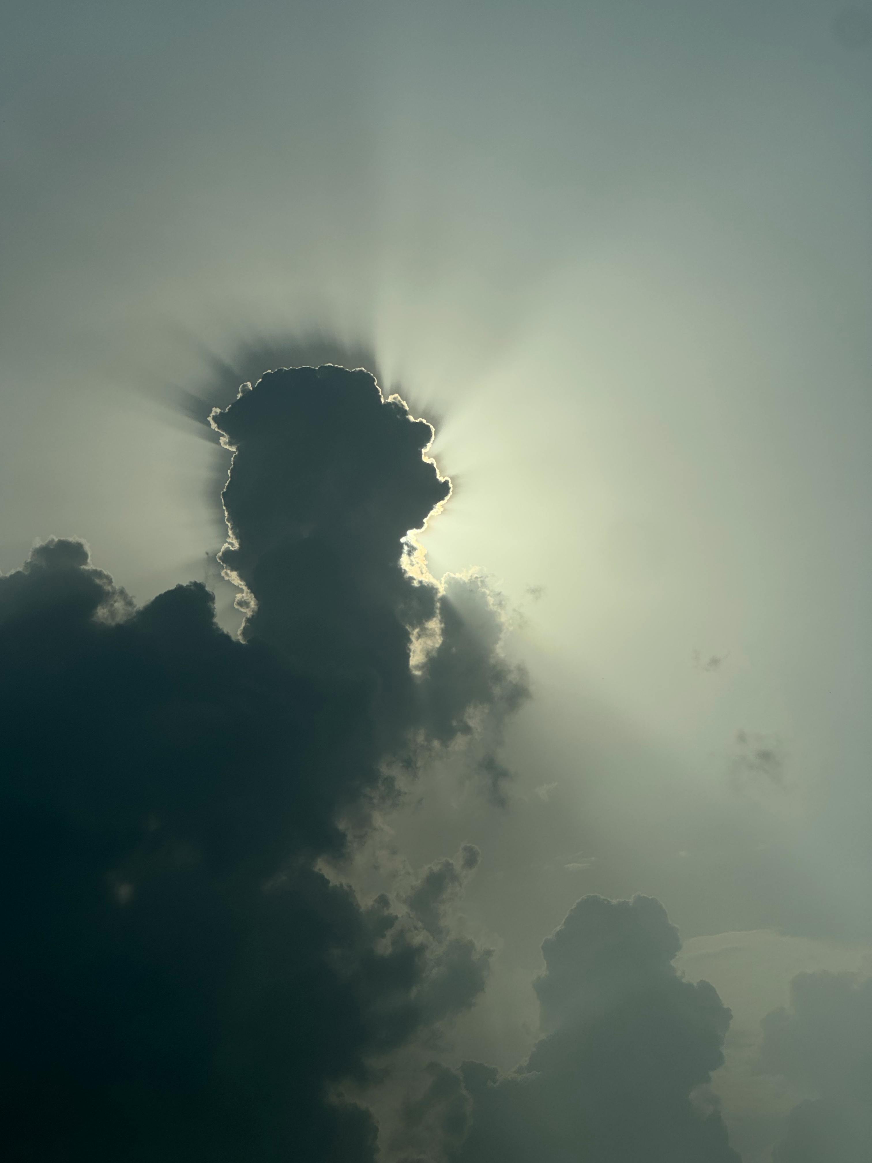 Gratis Fængslende billede af sollys, der bryder gennem skyerne og skaber en dramatisk silhuet. Lagerfoto