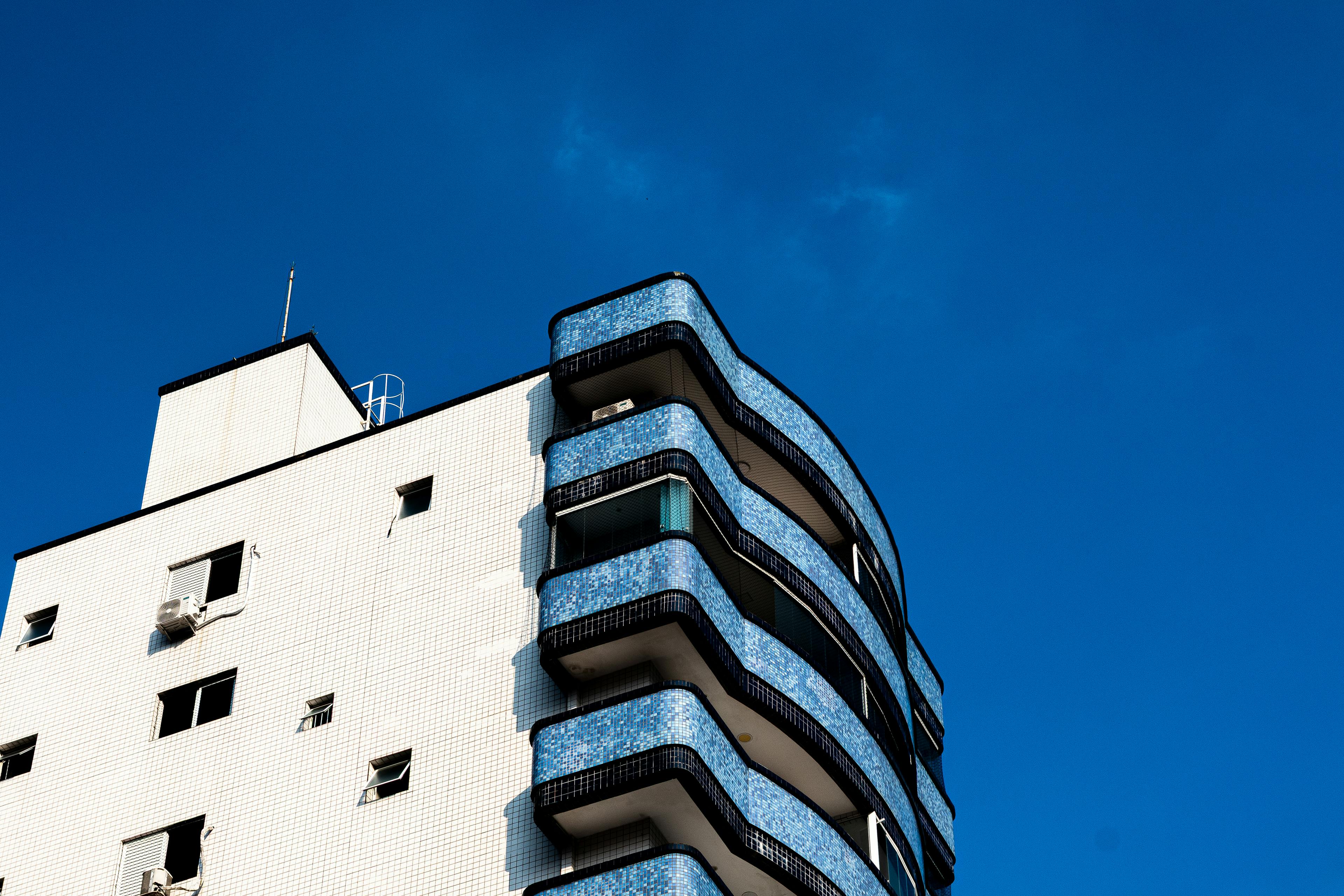 bezplatná Moderní architektonická budova s ​​modrými balkony a jasnou modrou oblohou. Základová fotografie