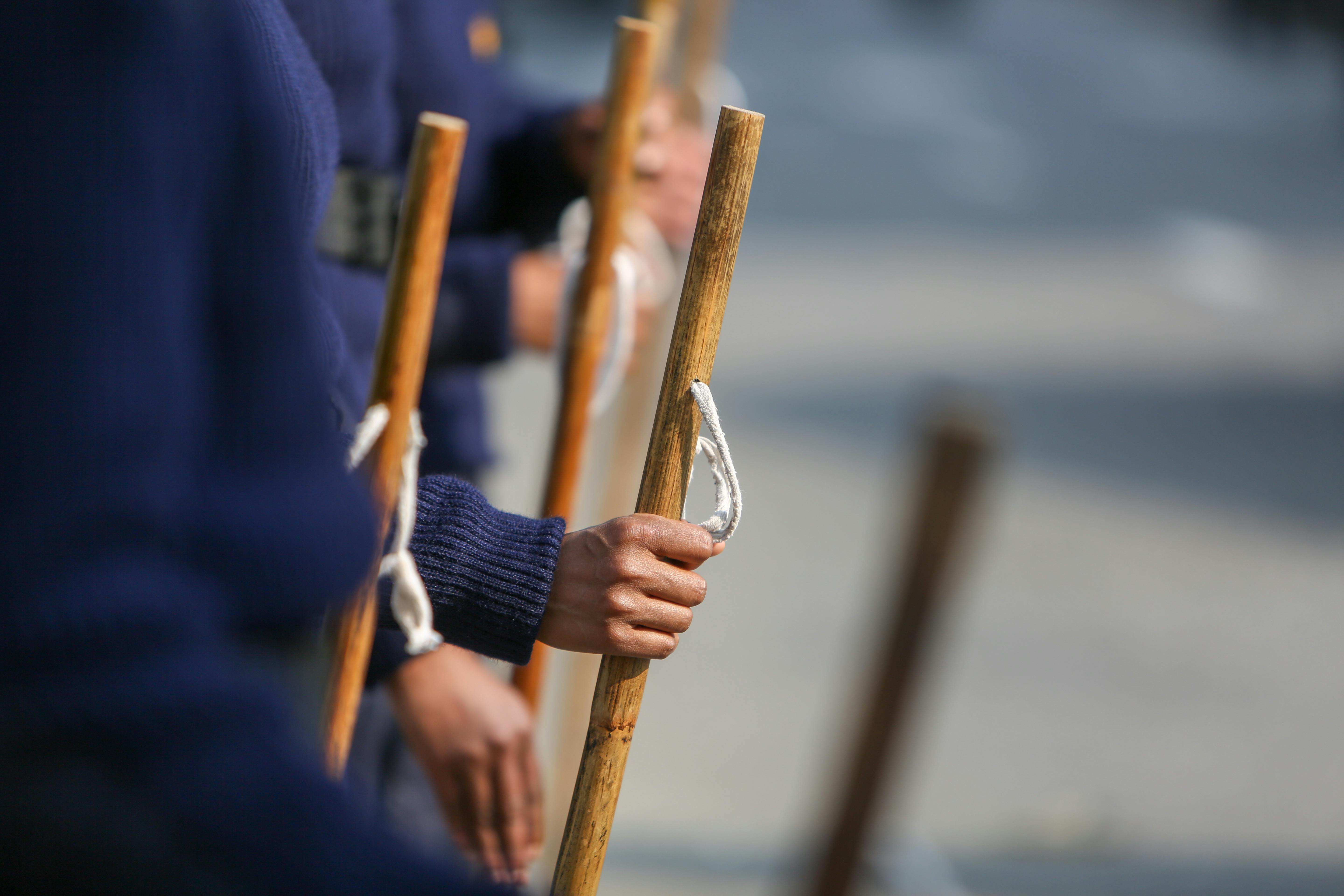 Gratuit Vedere în prim-plan a personalului militar care ține bețe de lemn în timpul unei parade, concentrată pe mâini și uniforme. Fotografie de stoc