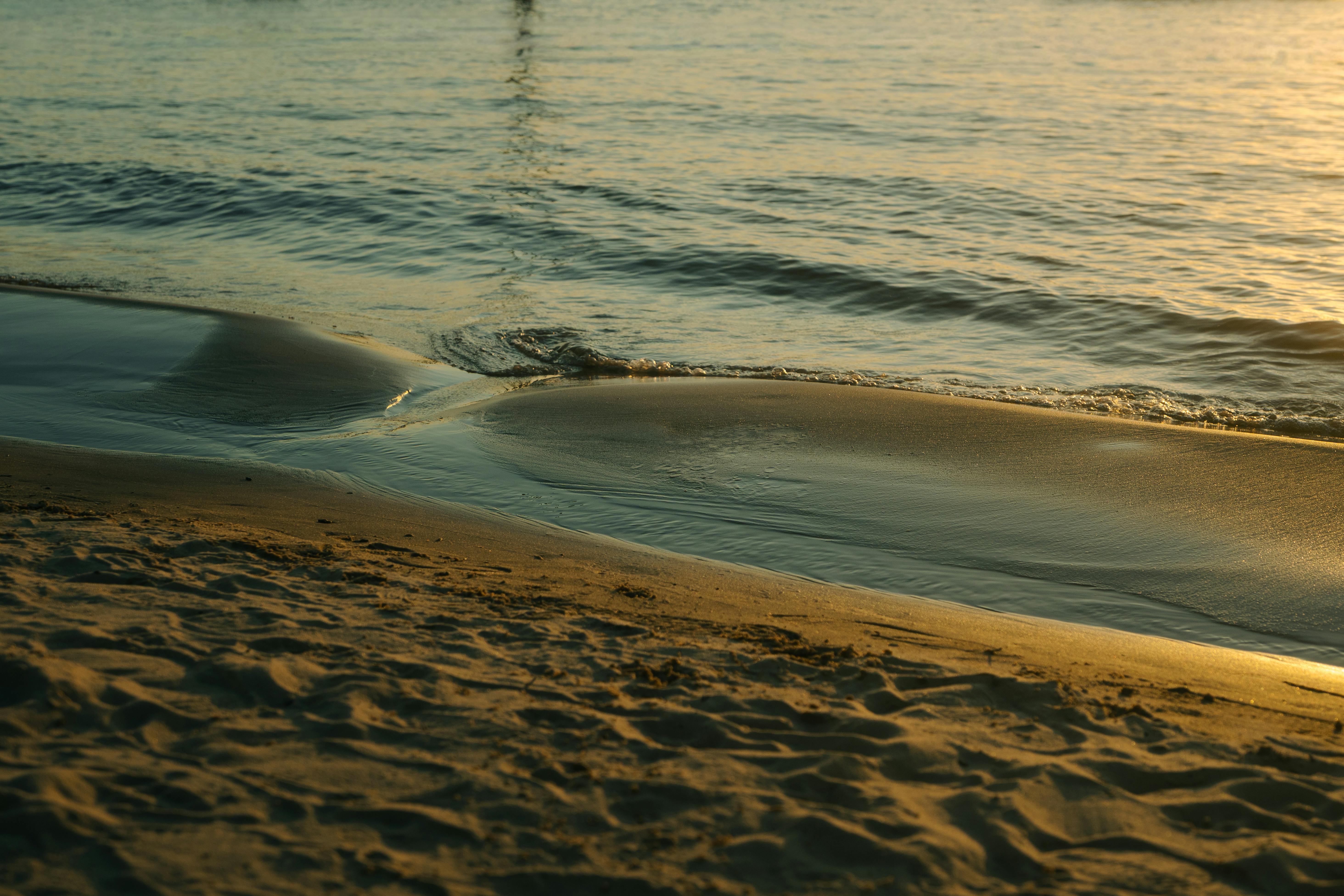 Gratis Scena serale serena con onde dolci e sabbia dorata su una spiaggia di Rosario in Argentina. Foto a disposizione