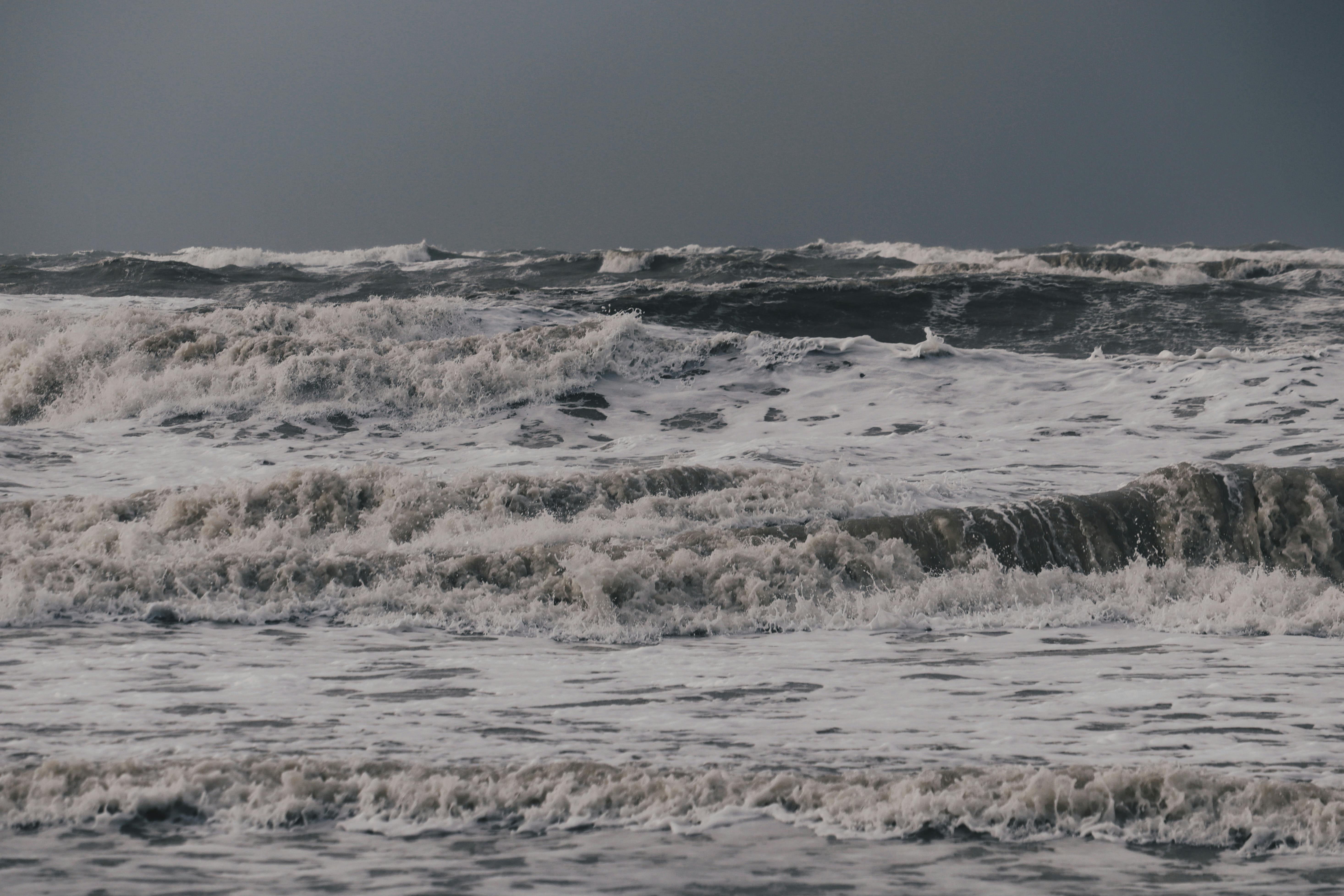 Безкоштовне Зйомка потужних океанських хвиль, що розбиваються під драматичним похмурим небом. стокове фото