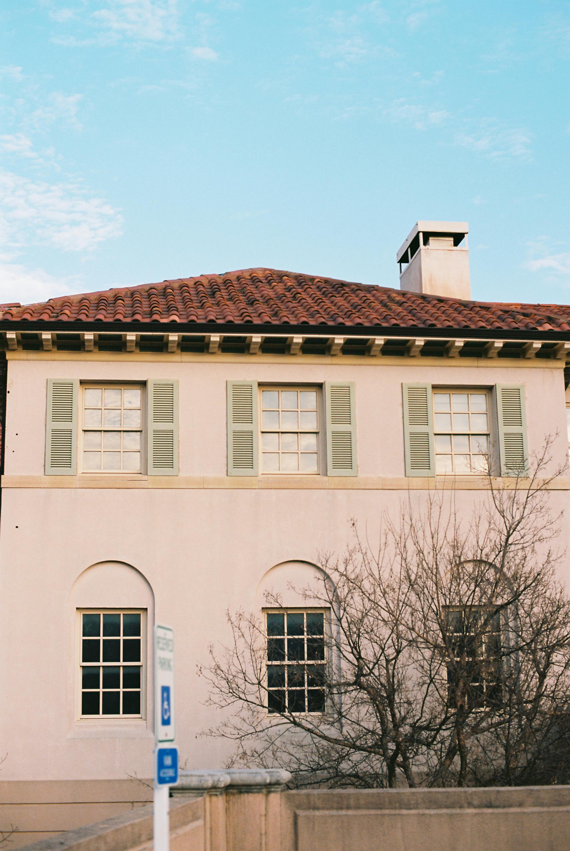 免費 迷人的地中海房屋，紅色的屋頂瓦片，綠色的百葉窗，在晴朗的天空下拍攝。 圖庫相片