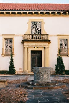 A classic facade of a historical building with a detailed courtyard fountain.