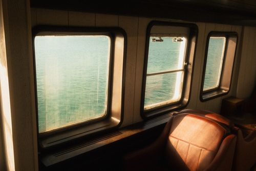 Free Tranquil view through ferry windows capturing İzmir's beautiful seaside. Stock Photo