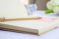 Elegant Notebook with Gold Pen and White Flowers