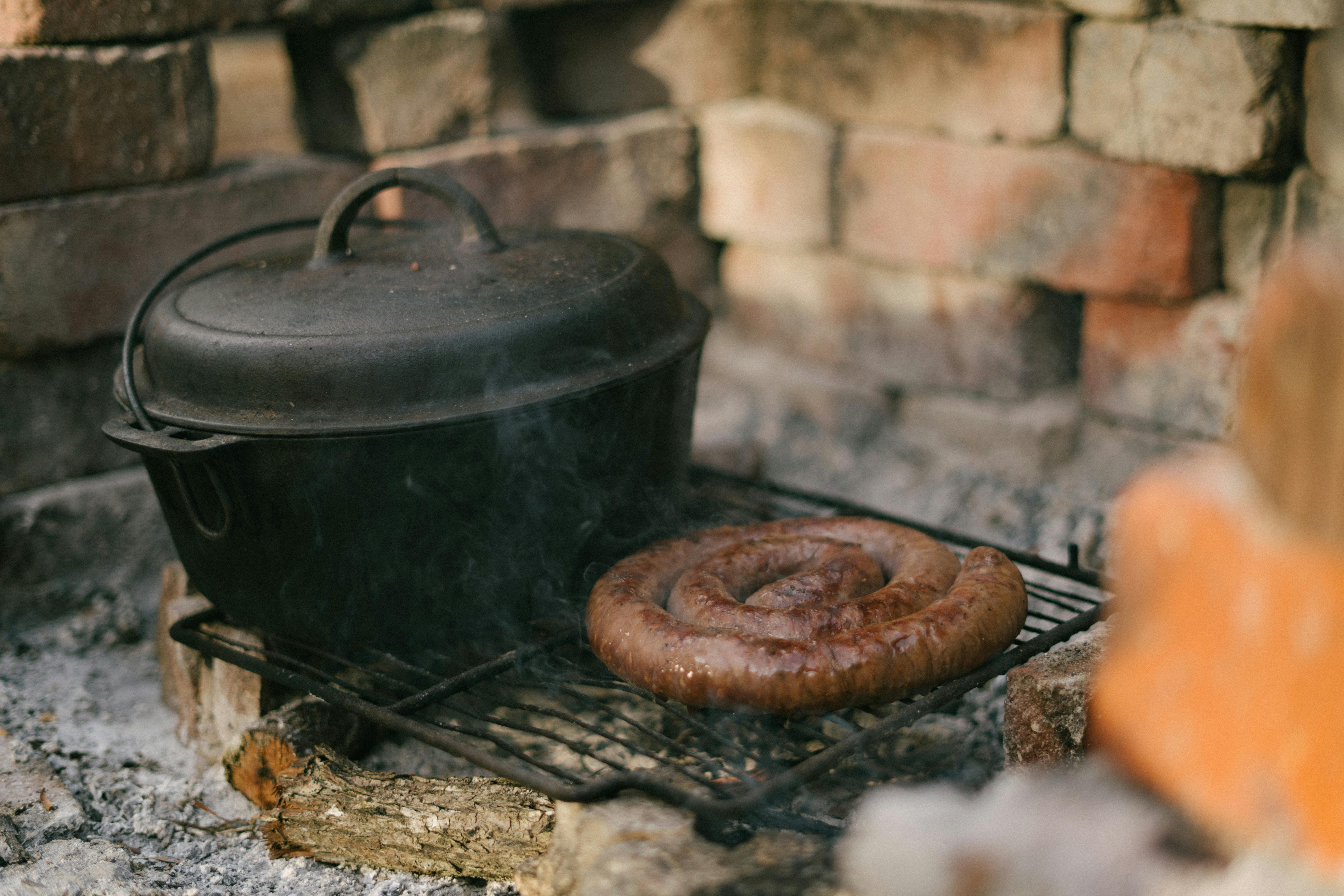 footlong sausage and black cooking pot on black metal grill