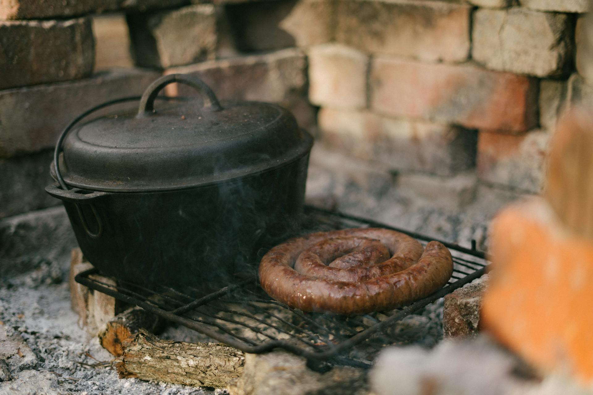 Footlong Sausage And Black Cooking Pot on Black Metal Grill