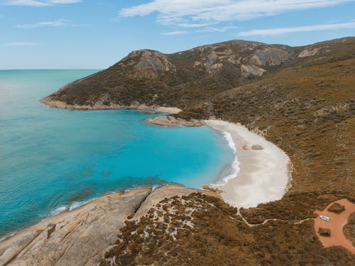 Brown Mountain Near Blue Sea Under Blue Sky