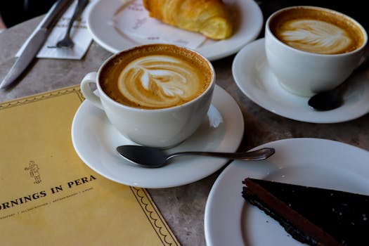 Warm cafe scene with cappuccinos, chocolate cake, and croissant, perfect for a cozy morning.