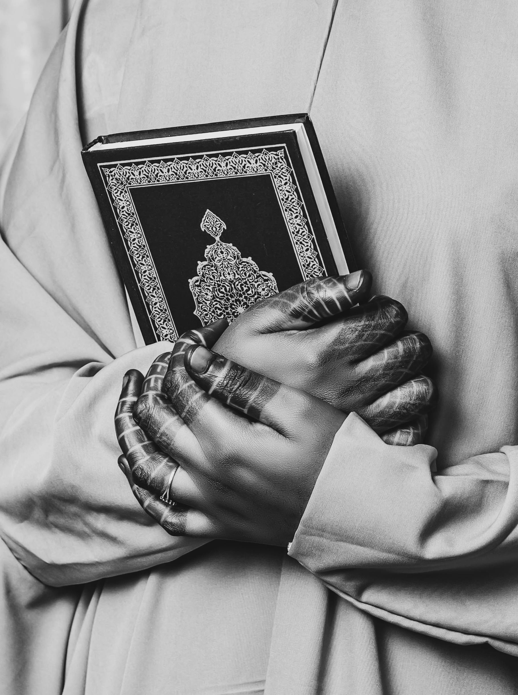 Ilmainen Mustavalkoinen valokuva hennataiteellisista käsistä, jotka pitelevät koristeellista kirjaa ja herättävät henkisyyttä. Kuvapankkikuva