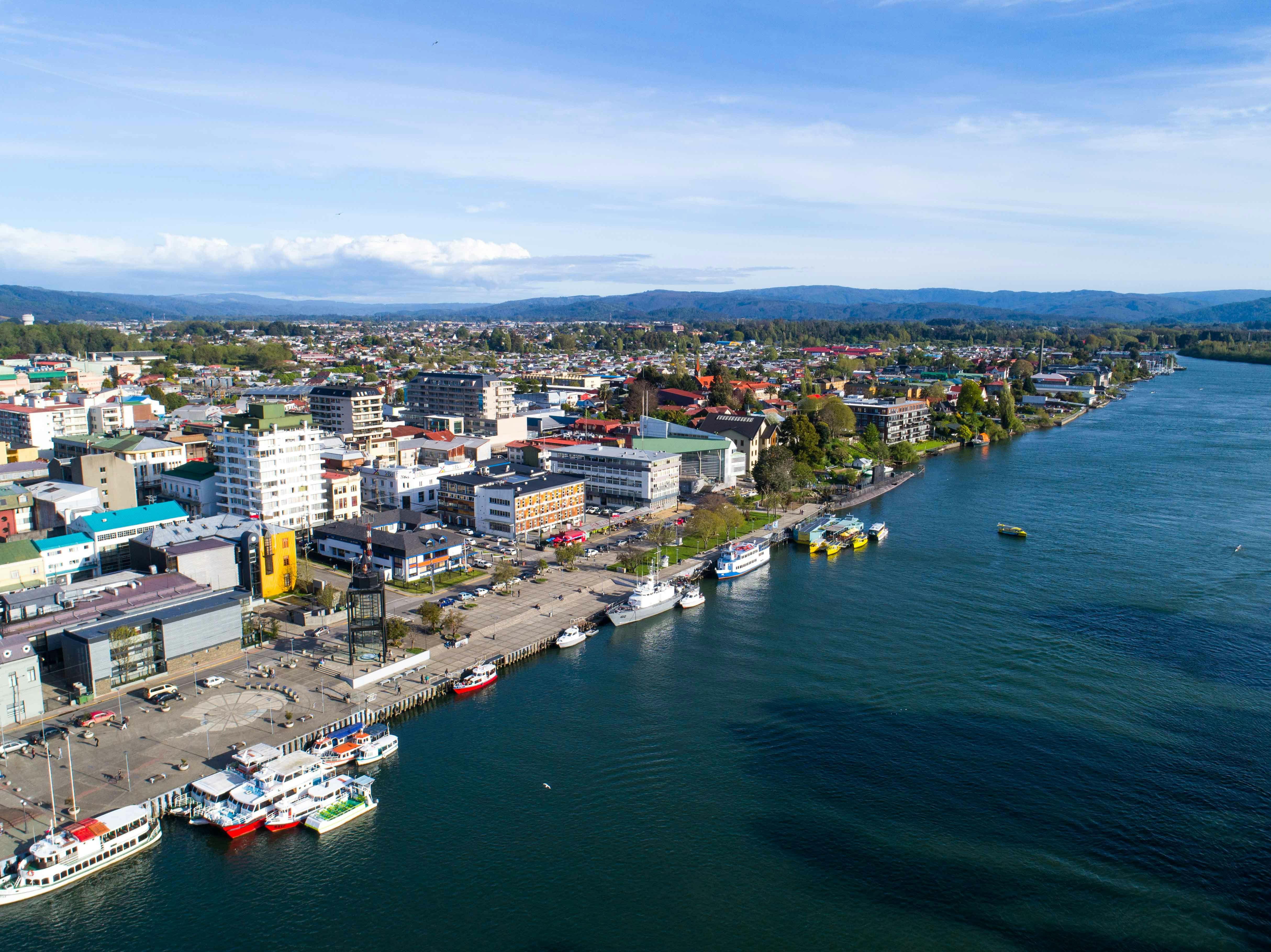 A stunning aerial view of a coastal city with vibrant buildings and a bustling waterfront.