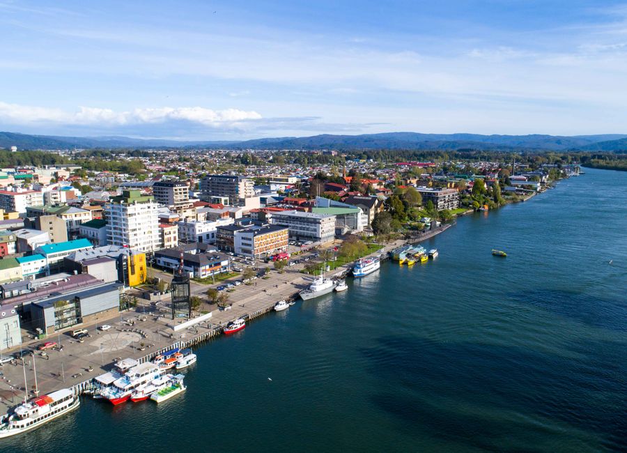 A stunning aerial view of a coastal city with vibrant buildings and a bustling waterfront.