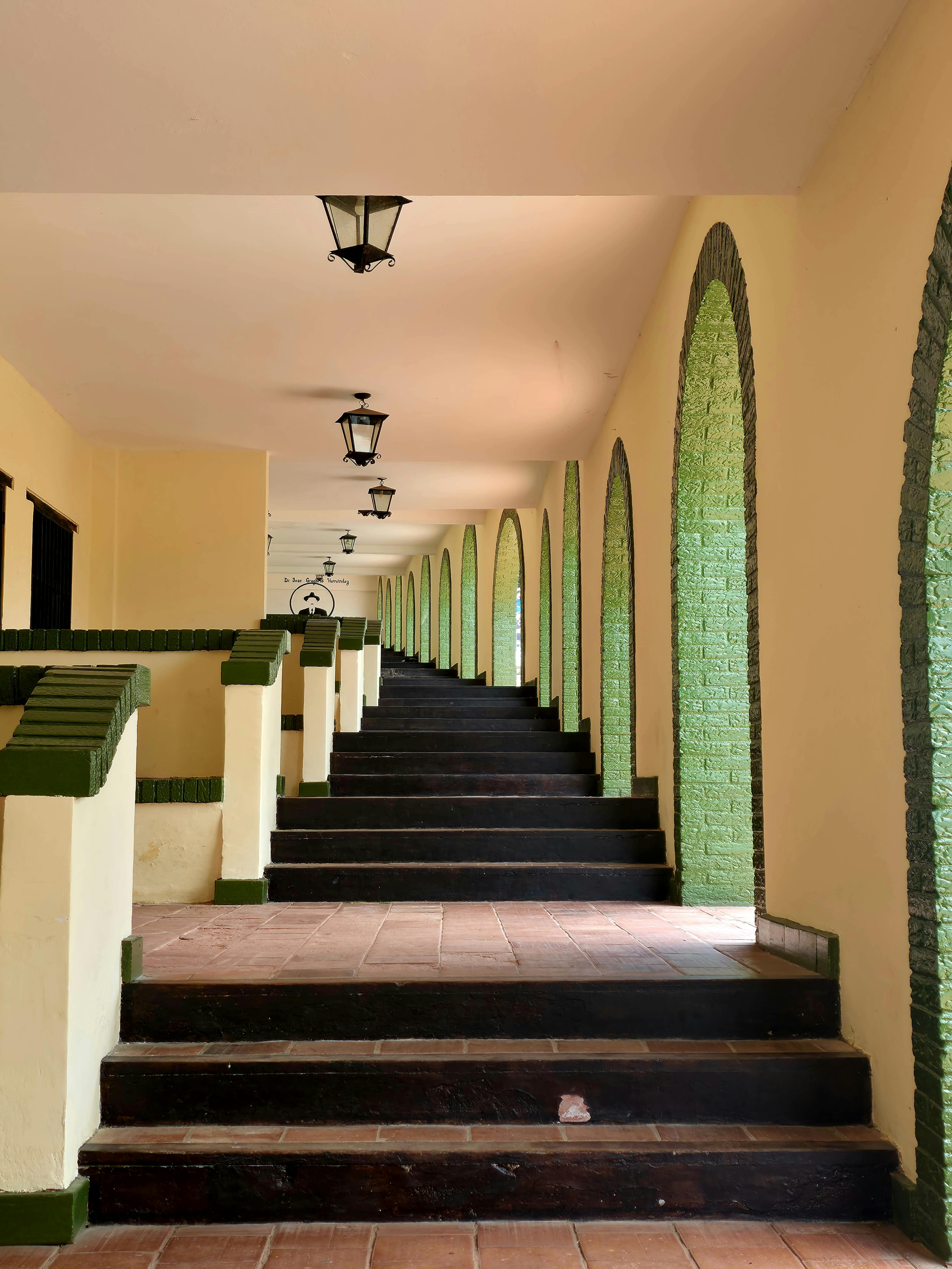 Ilmainen Kauniisti symmetrinen sisäkäytävä, jossa on kaaria ja lyhtyjä, tarjoaa klassisen ja elegantin tunnelman. Kuvapankkikuva