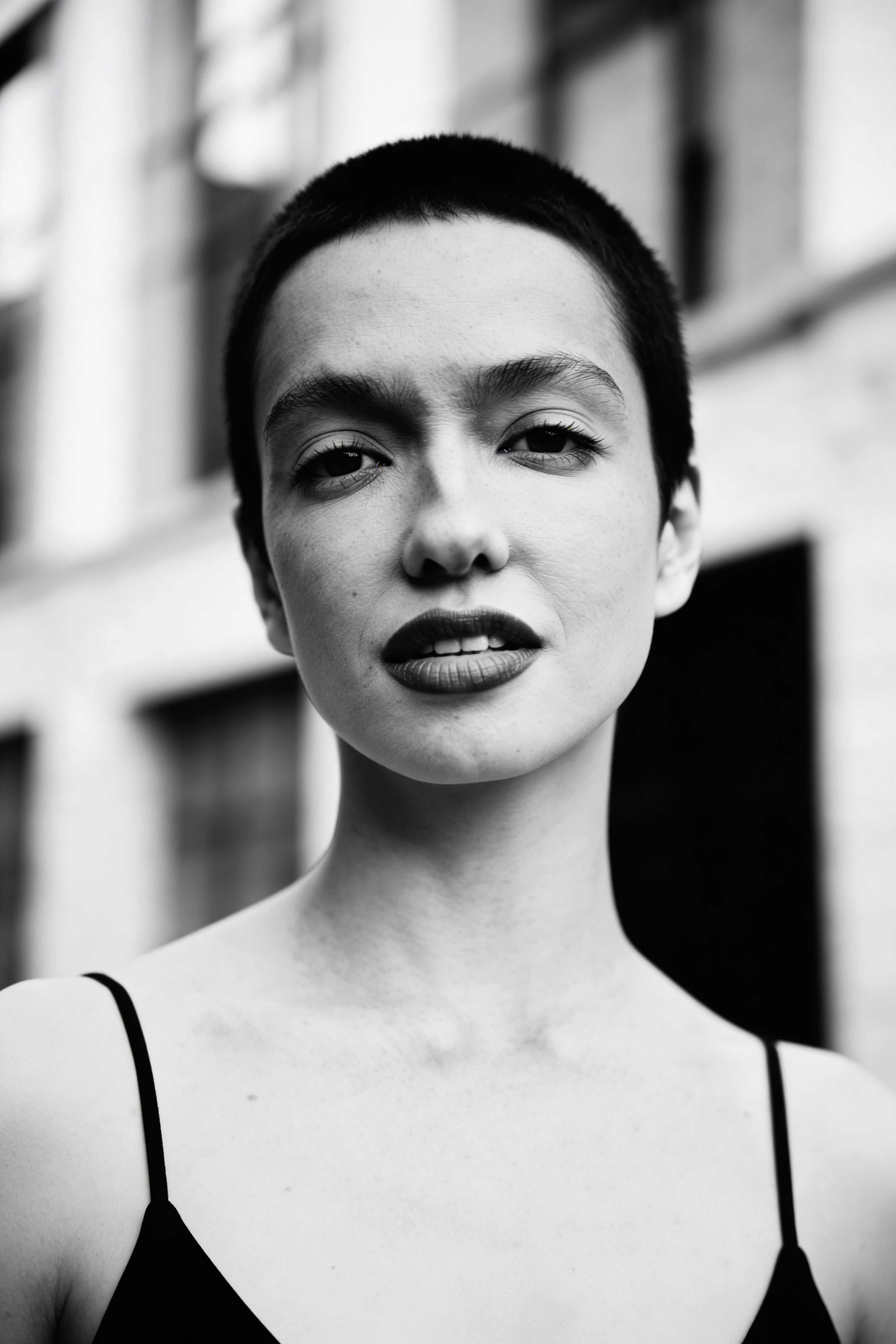 Striking black and white portrait of a young woman with short hair, expressing confidence.