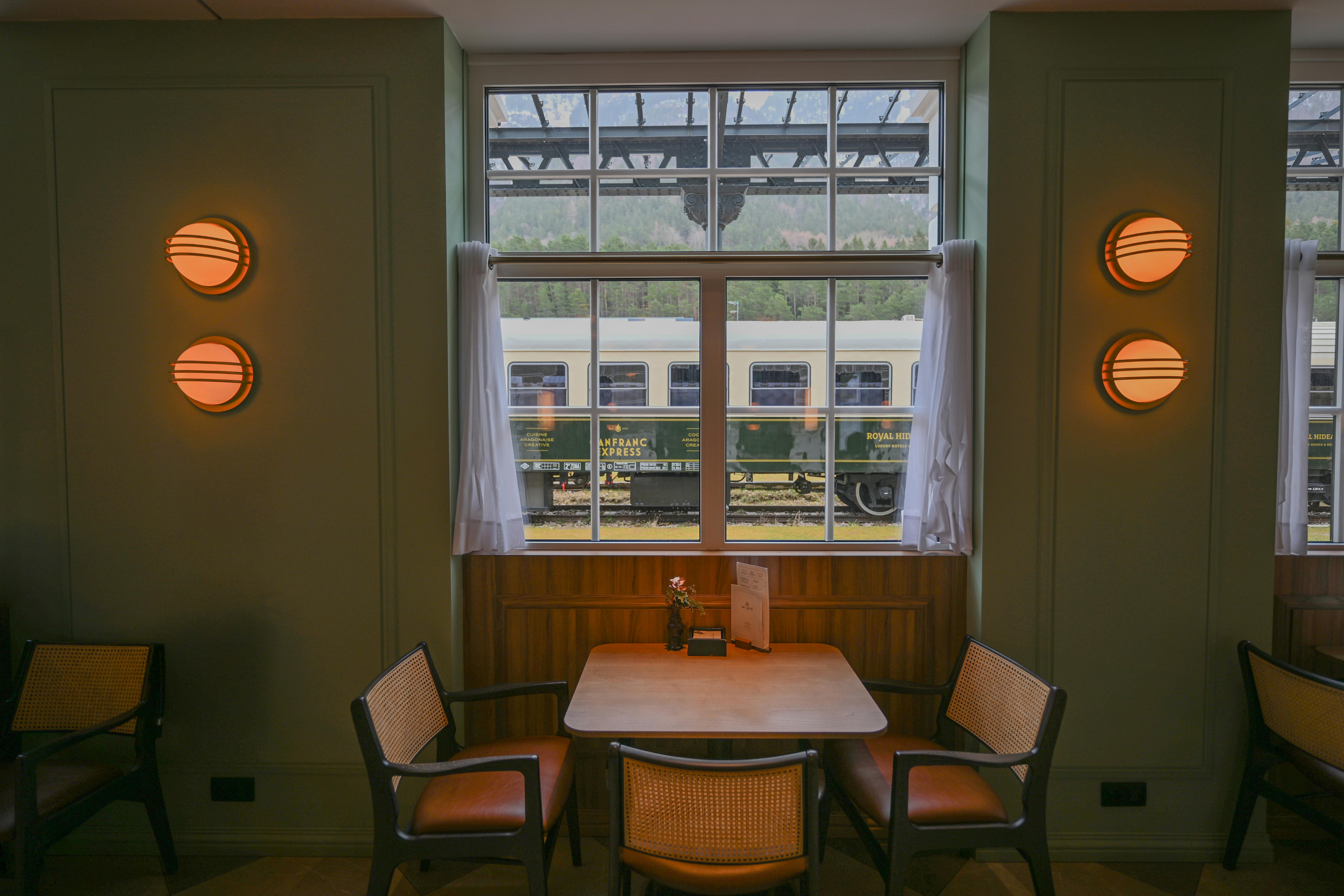 무료 아라곤 주 칸프랑크 역에 있는 아늑한 카페 내부. 창밖으로 기차가 지나간다. 스톡 사진