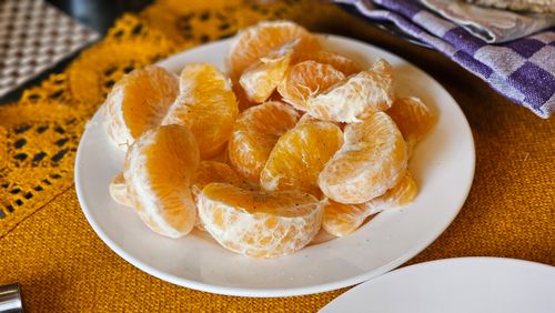 Free Close-up of juicy tangerine slices arranged on a white plate, capturing a fresh and vibrant look. Stock Photo
