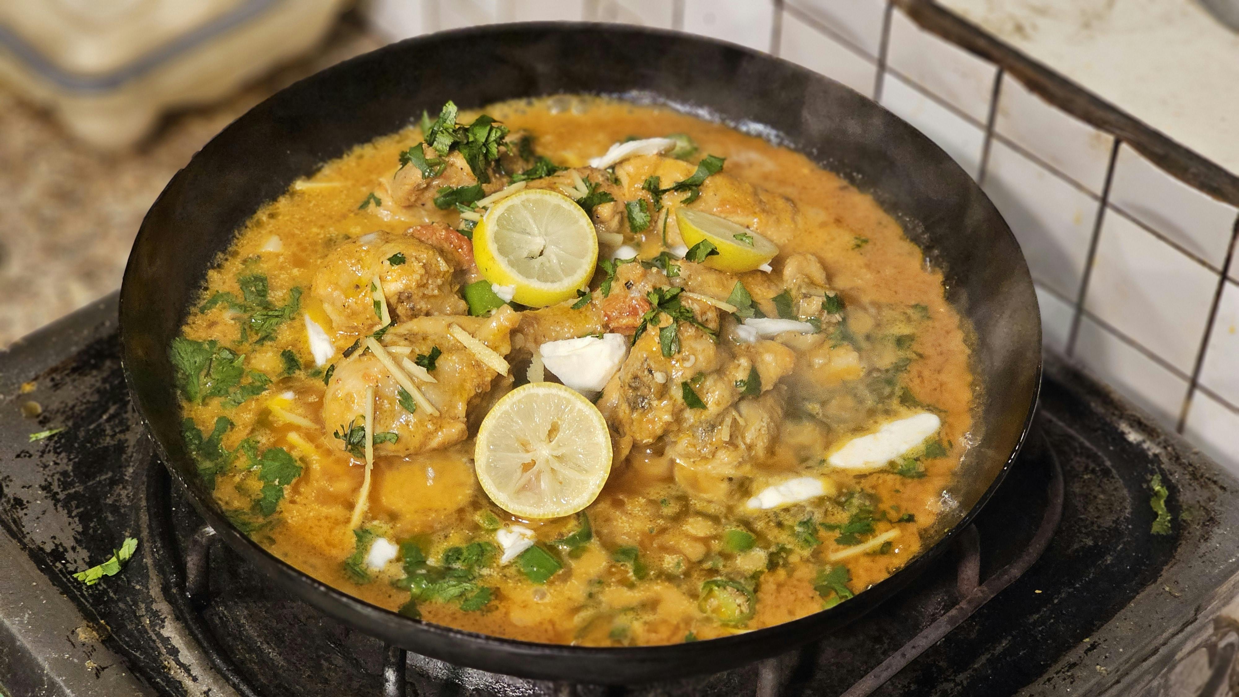 Gratis Un saporito curry di pollo guarnito con limoni e spezie, cotto alla perfezione in una padella rovente. Foto a disposizione