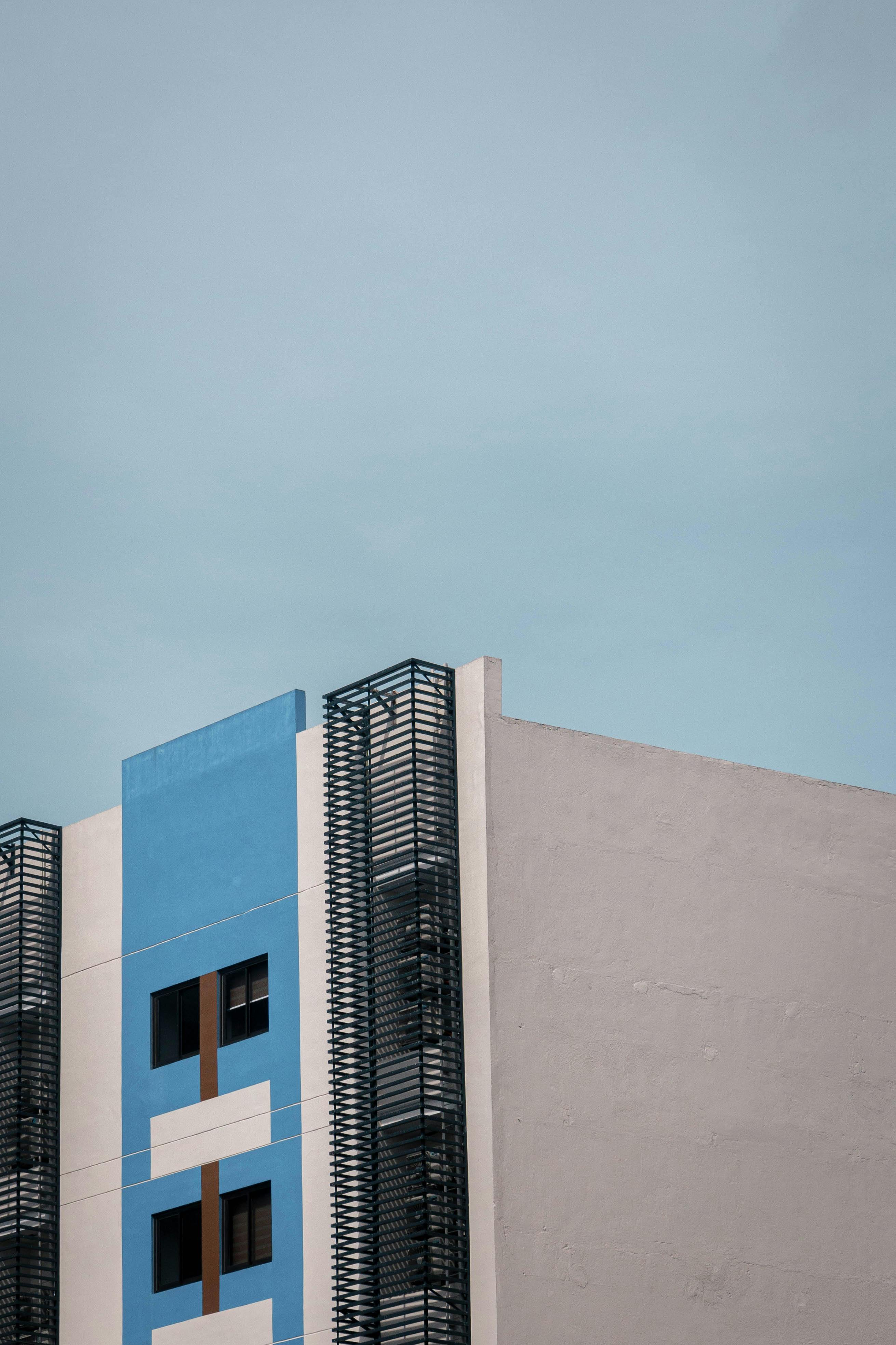 Free A modern building with a minimalist design set against a clear blue sky, showcasing urban architecture. Stock Photo