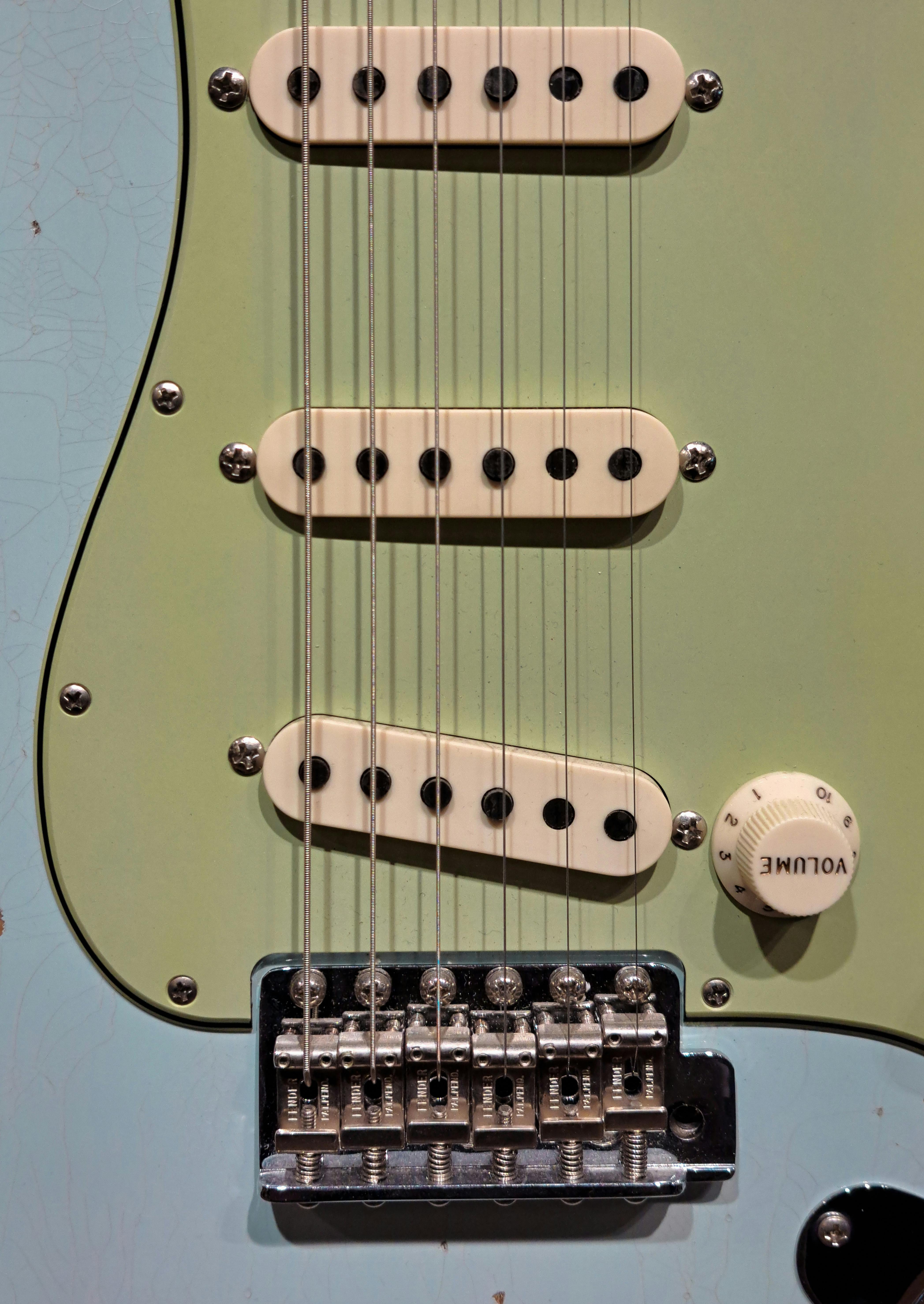 Ilmainen Yksityiskohtainen näkymä sähkökitarasta, jossa keskitytään kieliin, mikrofoneihin ja äänenvoimakkuuden säätönupiin. Kuvapankkikuva