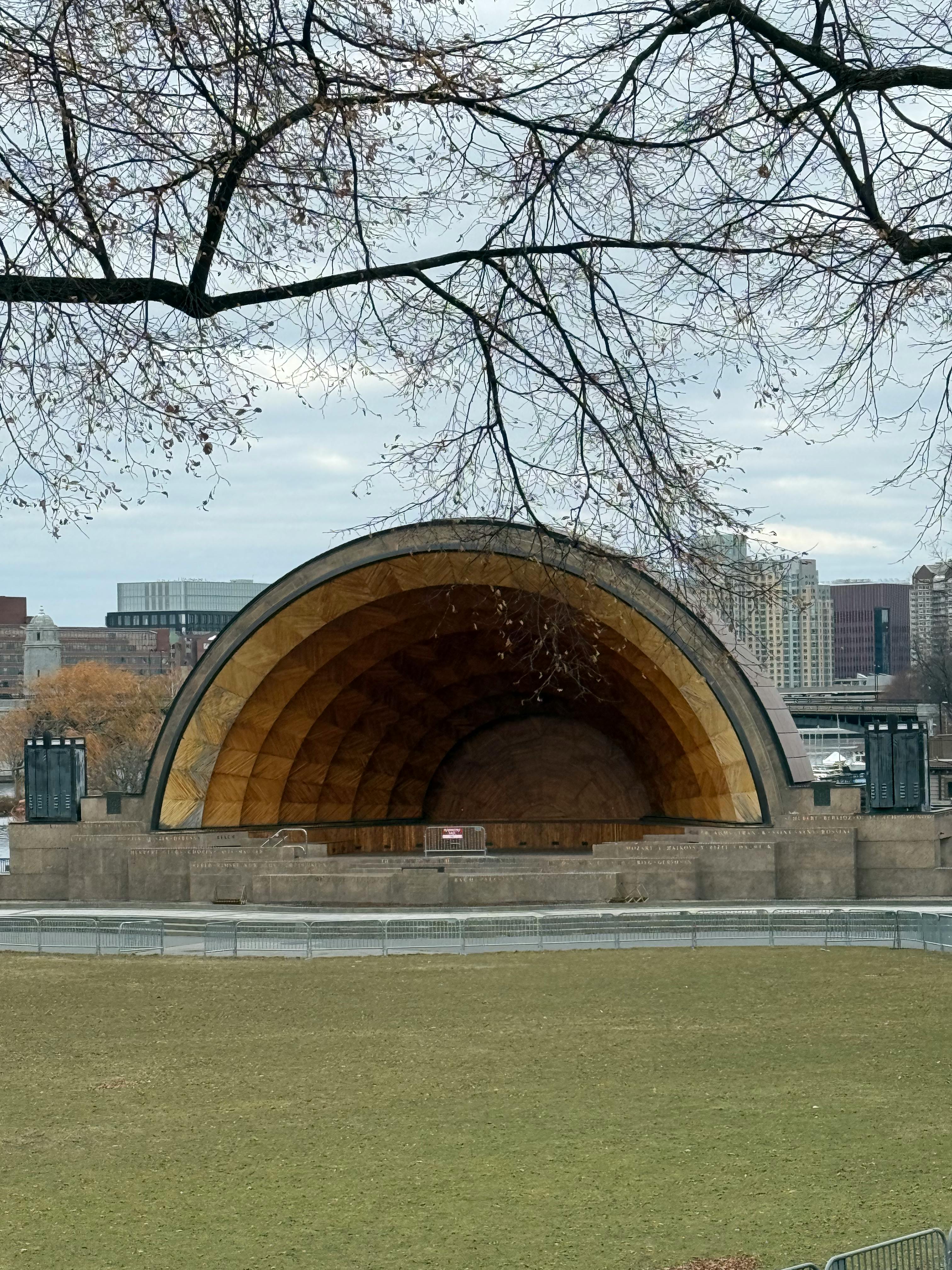 gratis Uitzicht op het Boston Hatch Shell amfitheater in de winter, met kale bomen en de skyline van de stad op de achtergrond. Stockfoto