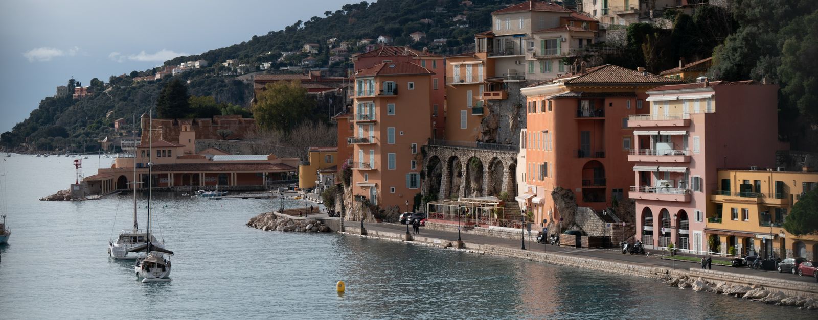 Picturesque coastal view of Villefranche-sur-Mer in the French Riviera, showcasing colorful buildings and calm waters.