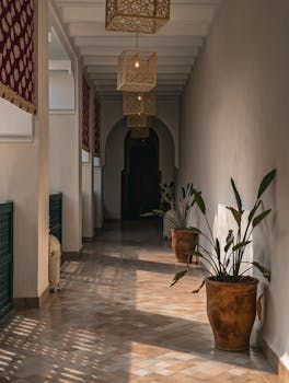 Peaceful Moroccan hallway with potted plants and intricate hanging lanterns, Marrakesh, Morocco.