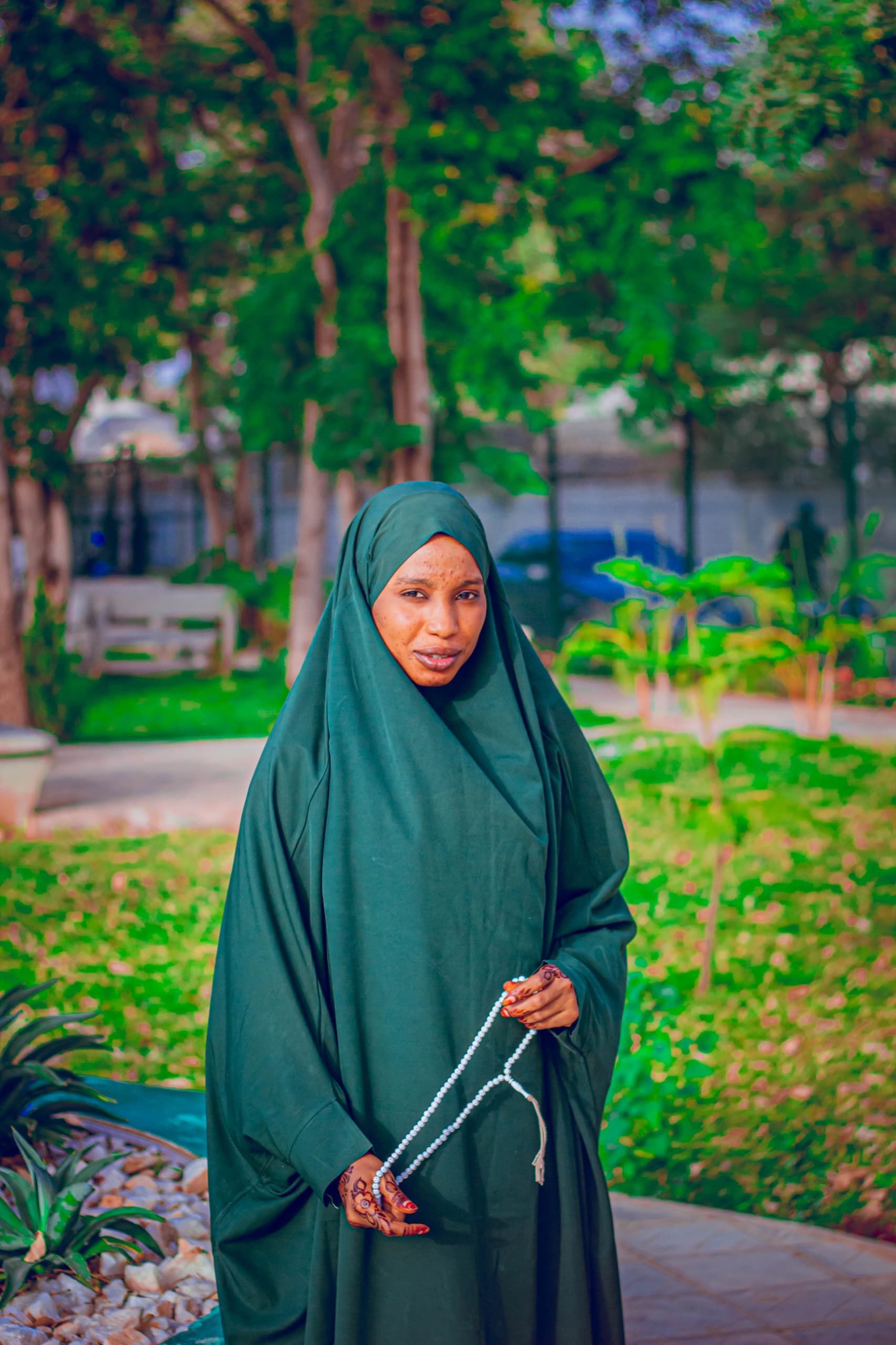 Woman in Green Hijab Holding Prayer Beads Outdoors · Free Stock Photo