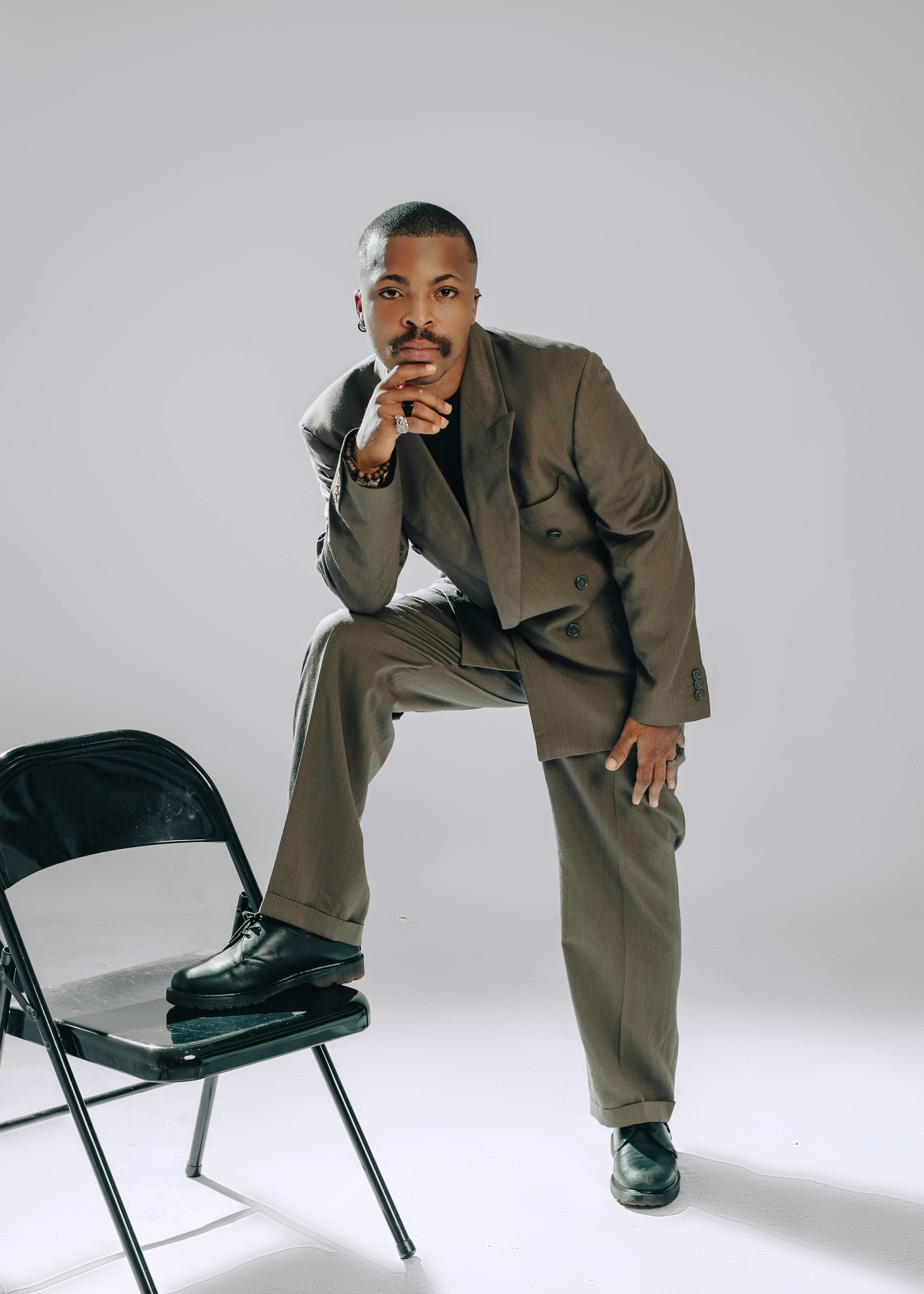 Miễn phí Một người mẫu nam tự tin trong bộ vest cổ điển tạo dáng đầy phong cách trong nhà. Ảnh lưu trữ