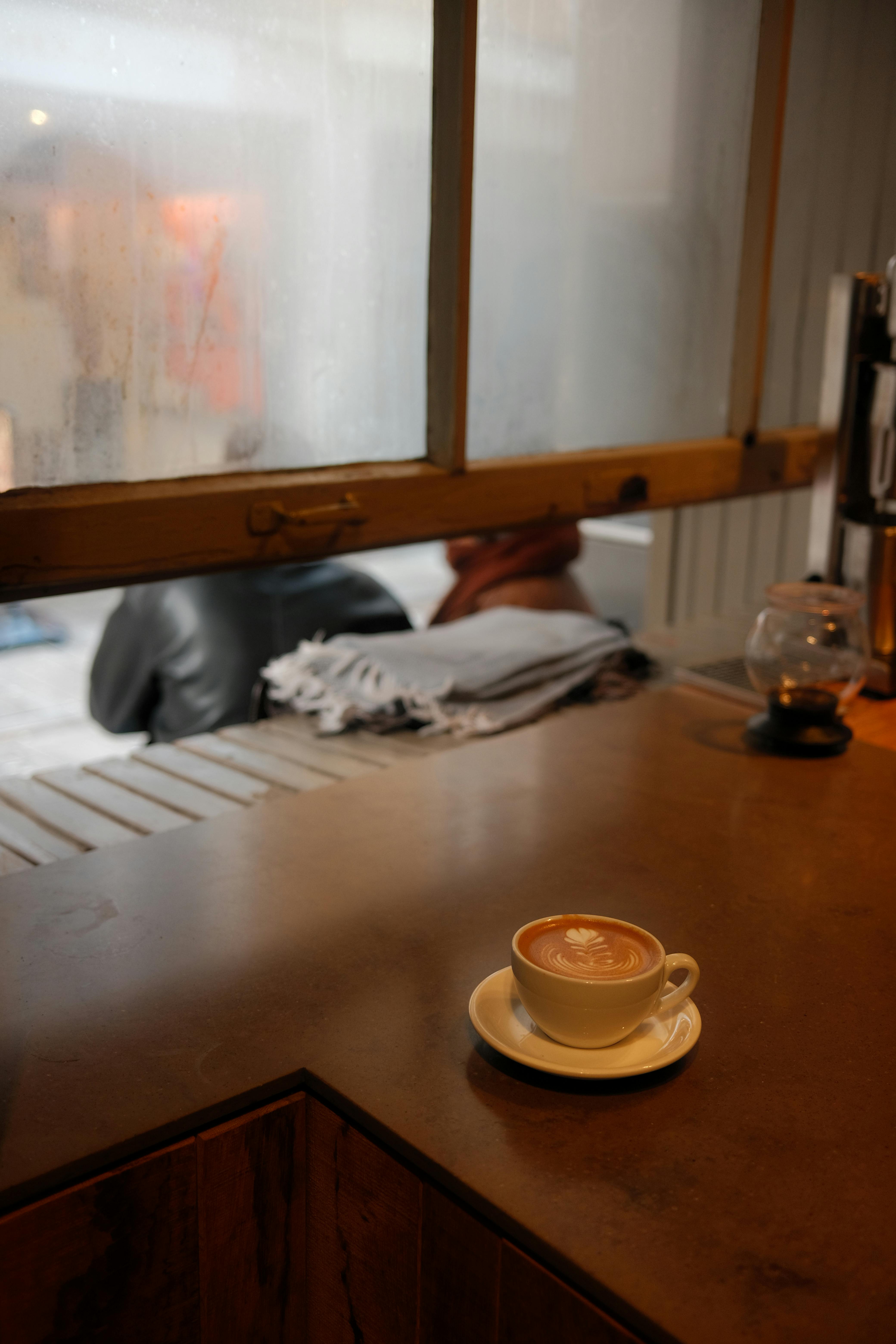 Bezpłatne Ciepłe cappuccino na blacie w miejskiej kawiarni z rozmytym tłem. Zdjęcie z galerii