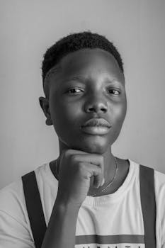 这幅黑白肖像经过深思熟虑，描绘了一个年轻人用手托着下巴的样子