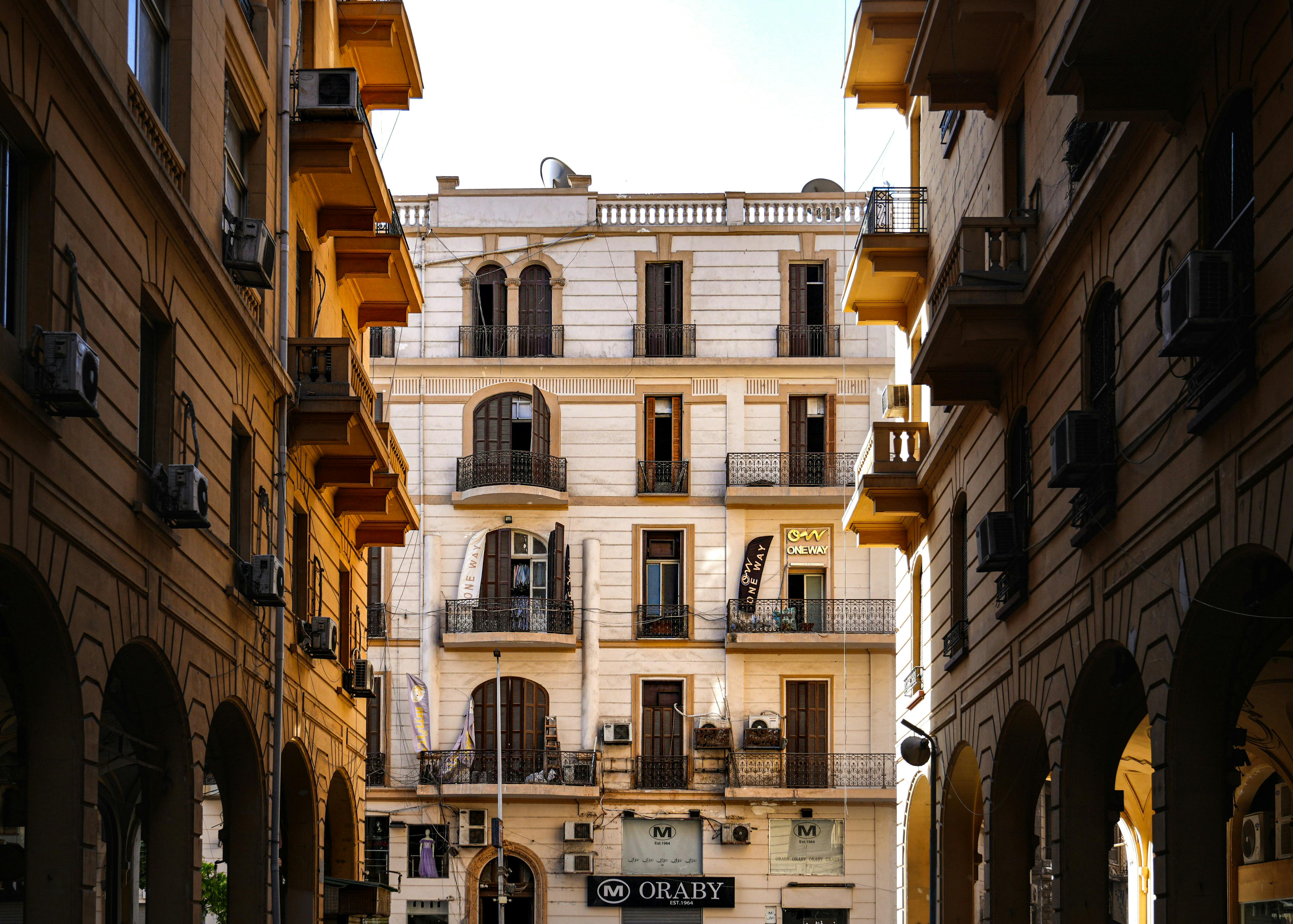 Gratis Un classico condominio in stile europeo incorniciato da edifici ad arco, immortalato in piena luce del giorno. Foto a disposizione