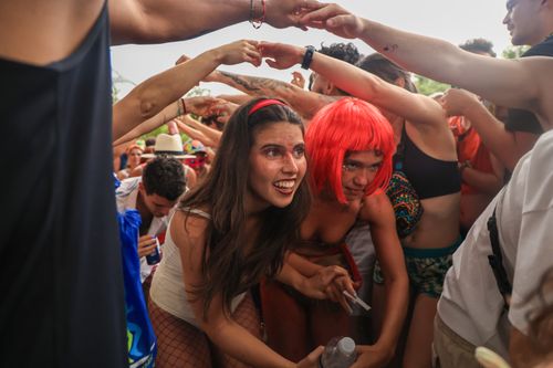Free Energetic carnival scene with costumed adults enjoying lively music and festivities outdoors. Stock Photo