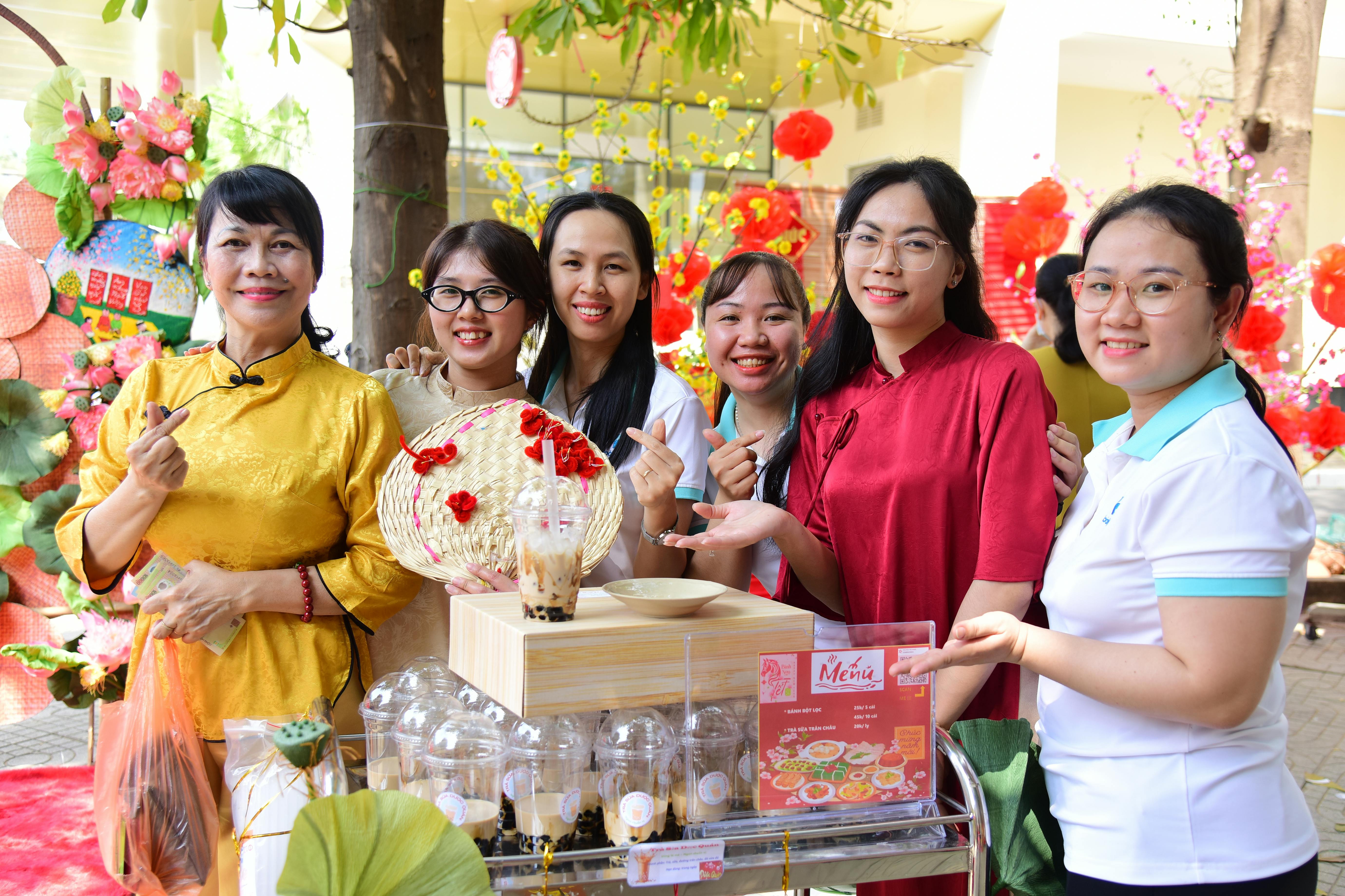 A joyful group of women in traditional attire enjoying a festive outdoor event.